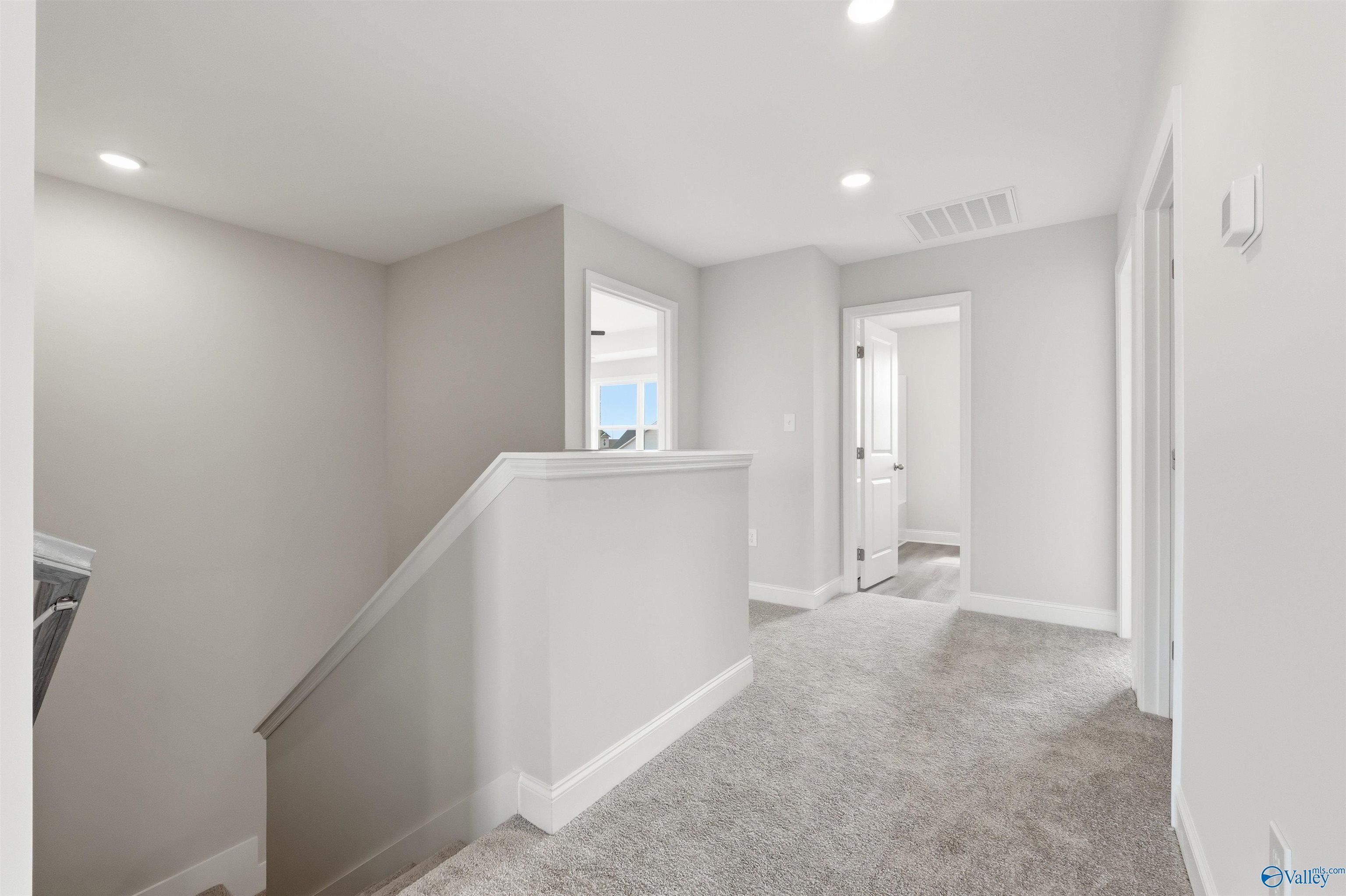 Bright upstairs carpeted landing and hallway in The Shelby D floor plan by Davidson Homes in Evergreen Mill, Madison, AL.