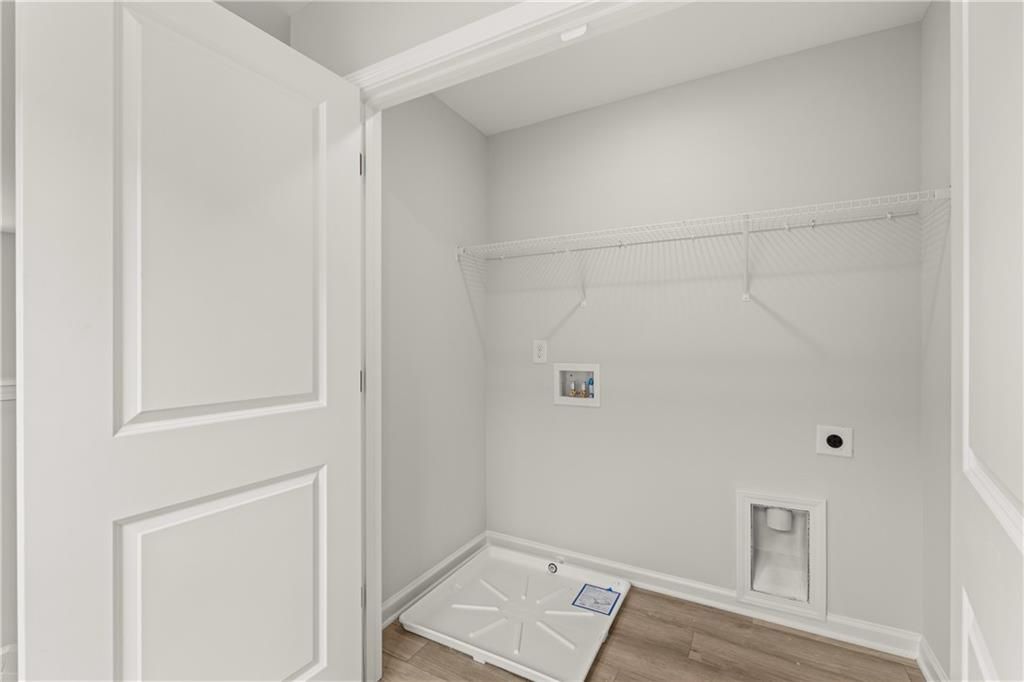 Laundry closet with white wire shelving and hookups in The Hartwell A floor plan at The Bluffs in Canton, Georgia.