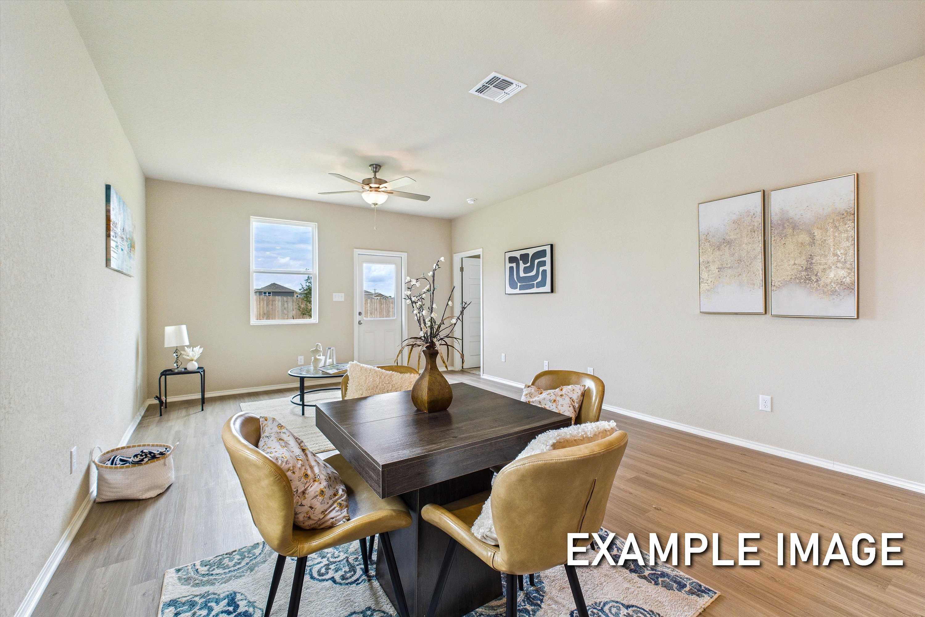 Modern dining room with dark wood table, upholstered chairs, abstract wall art, and French doors in The Comal B by Davidson Homes, Agave San Antonio