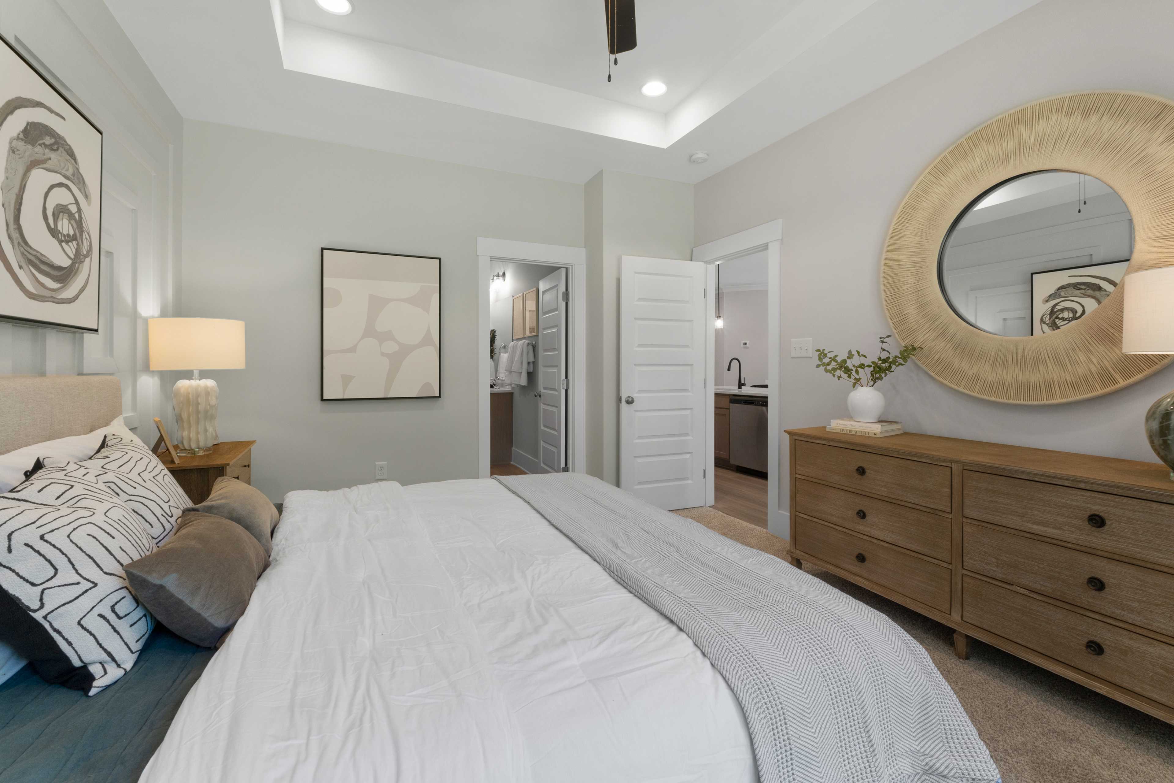 Spacious primary bedroom at Hollon Meadow in Decatur Alabama with king bed, gold mirror, and en-suite bath