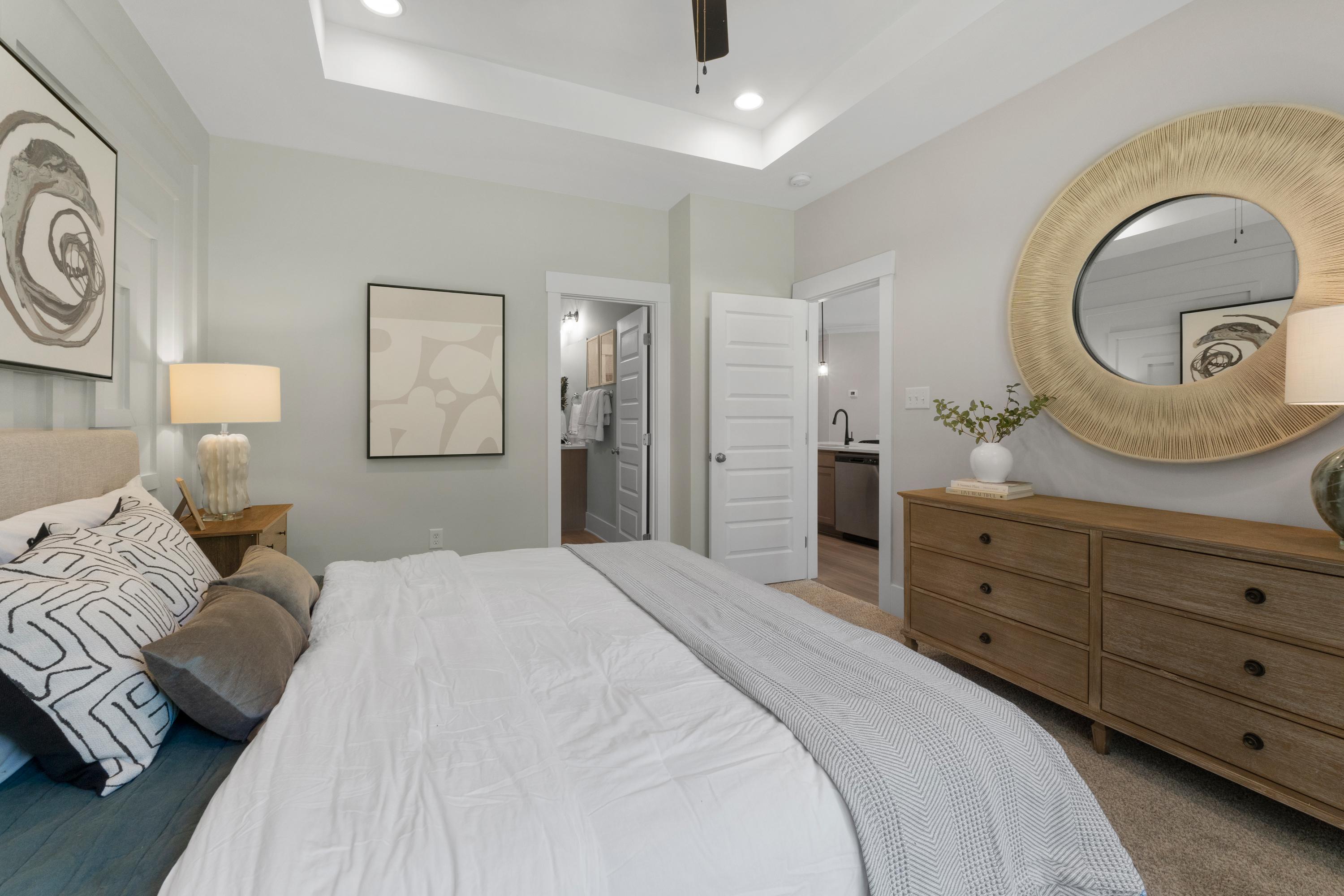 Spacious primary bedroom at Hollon Meadow in Decatur Alabama with king bed, gold mirror, and en-suite bath