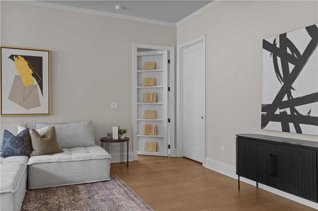 Cozy living room with gray sectional sofa, abstract art, built-in bookshelves in Davidson Homes The Seaside B, Woodstock, Georgia