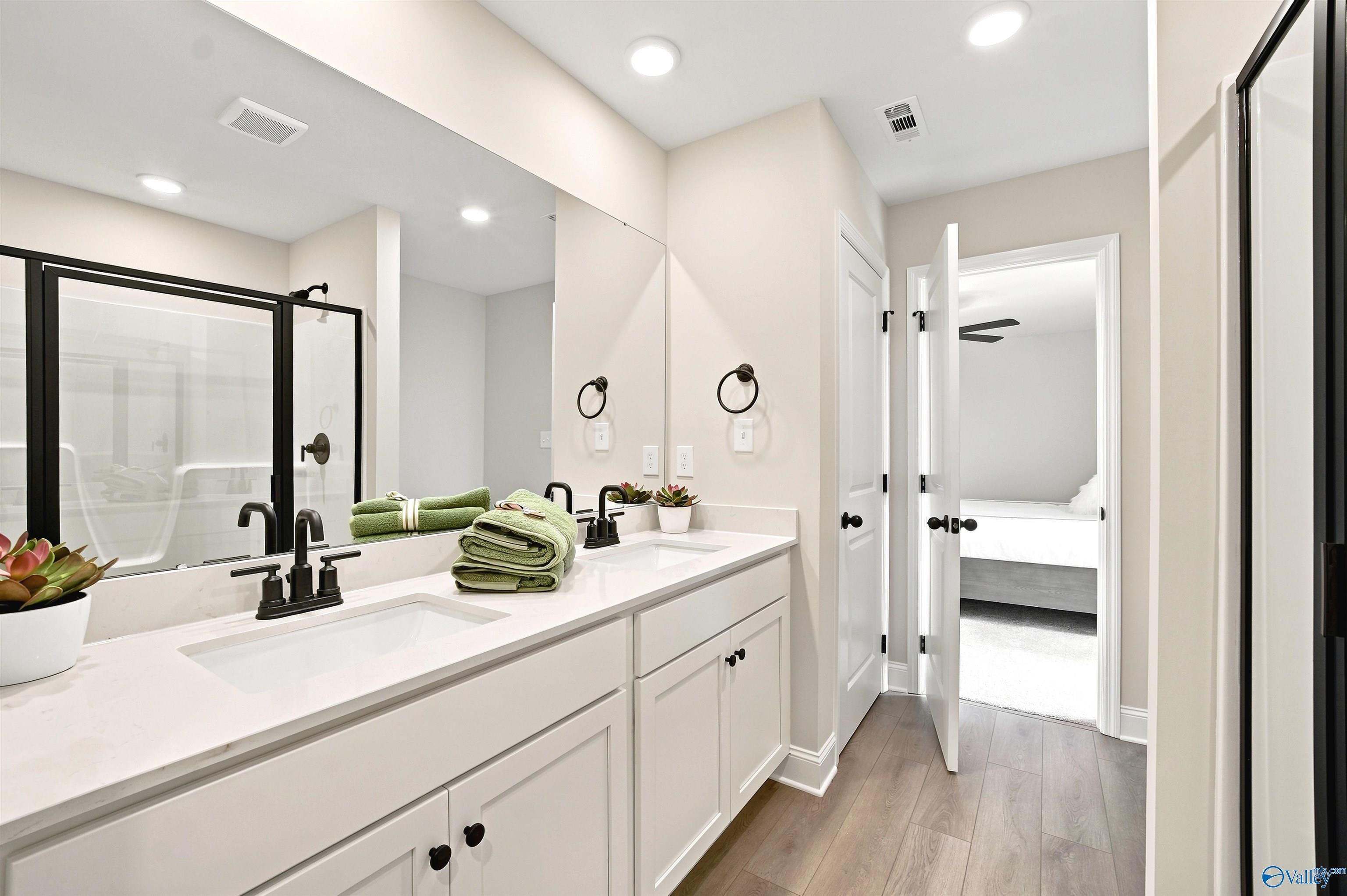 Modern double vanity bathroom with glass shower in The Burton B floor plan at Heritage Lakes, New Market, Alabama.