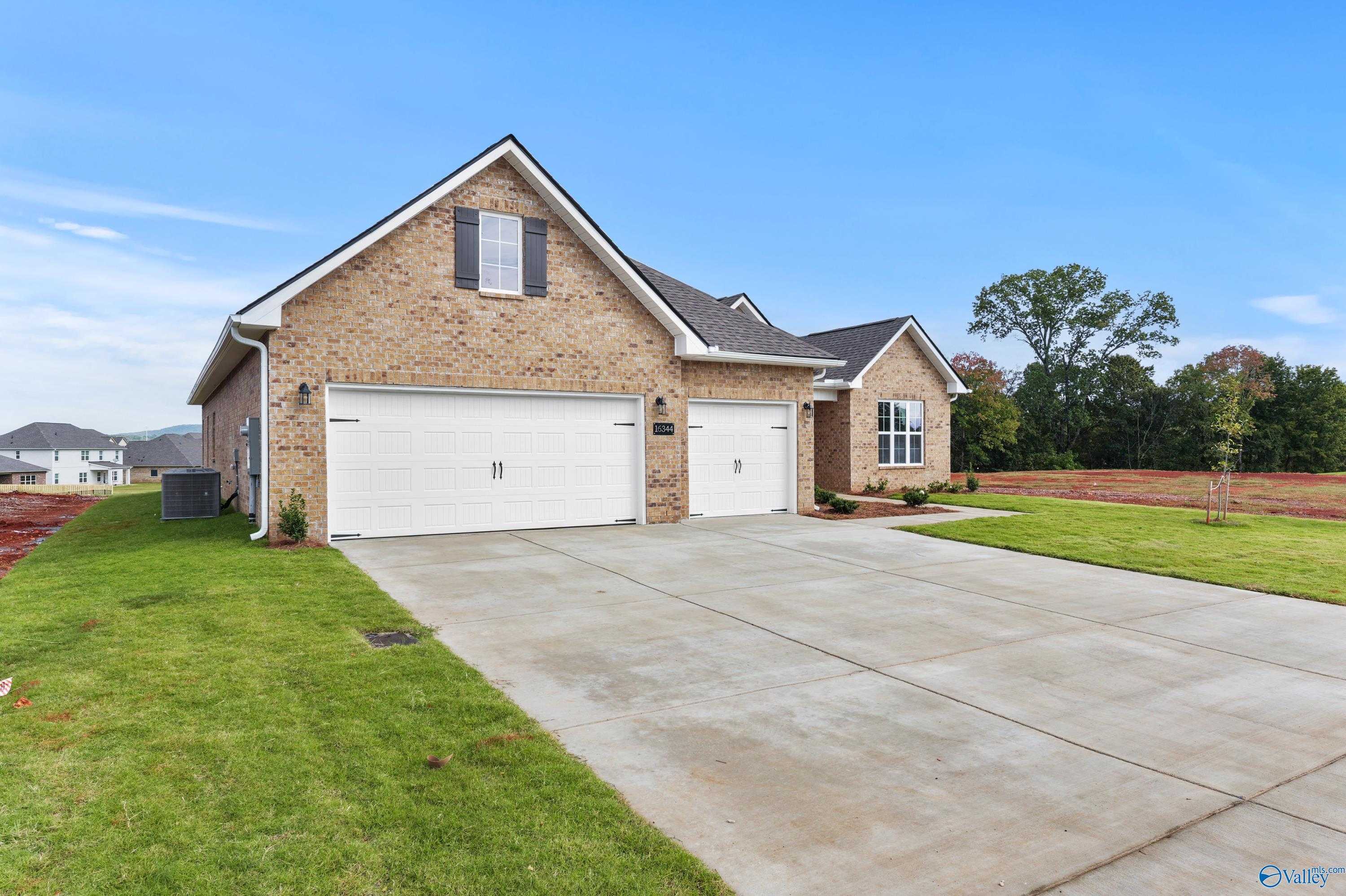 Modern brick ranch home with 3-car garage and driveway in Creekside, Harvest, Alabama by Davidson Homes The Finleigh