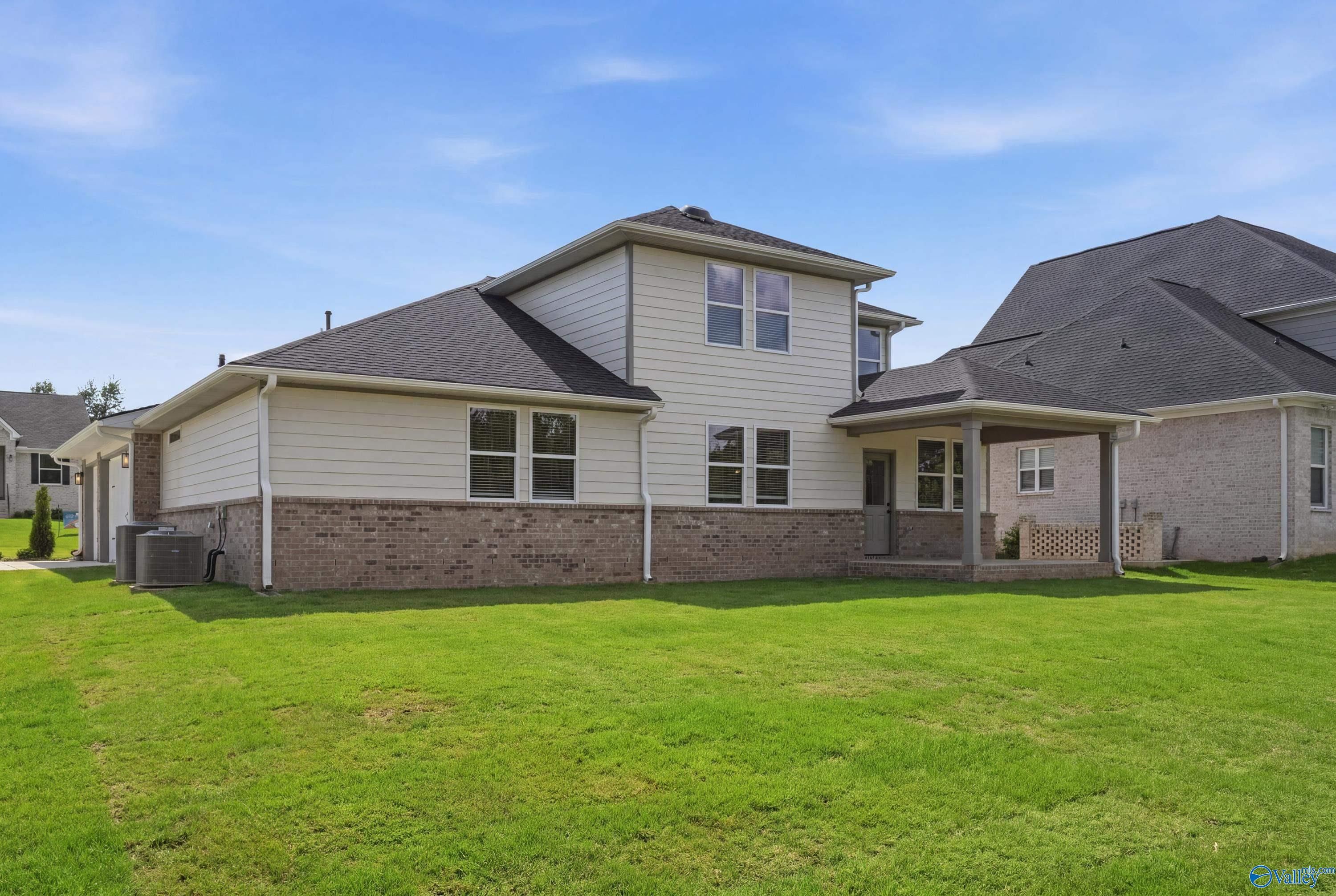 Rear view of two-story Dorado floor plan by Davidson Homes with covered patio and large yard in Riverton Preserve, Huntsville.