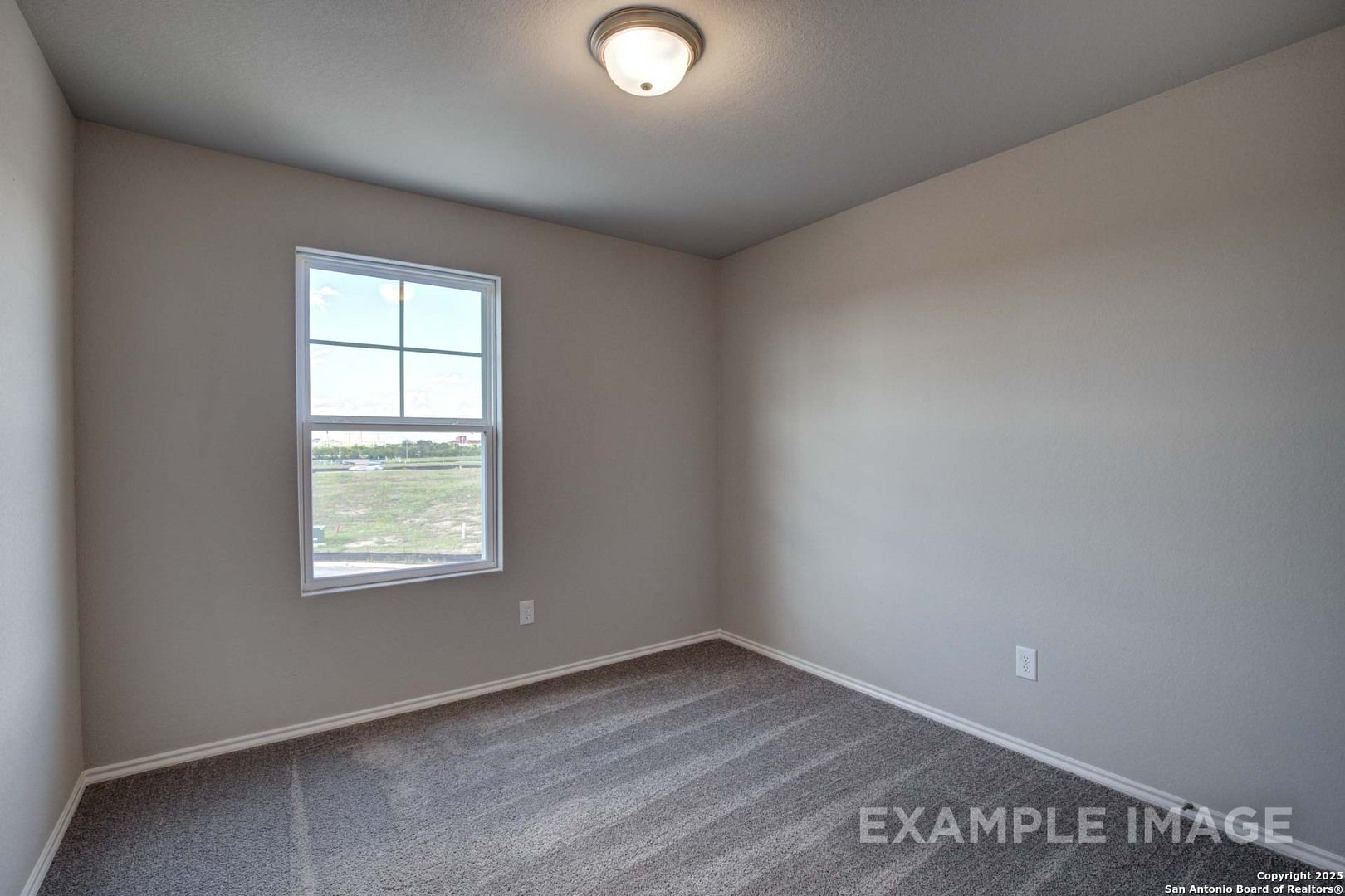 Empty bedroom with neutral beige walls, gray carpet flooring, and large window with prairie view in Davidson Homes The Blanco C, San Antonio