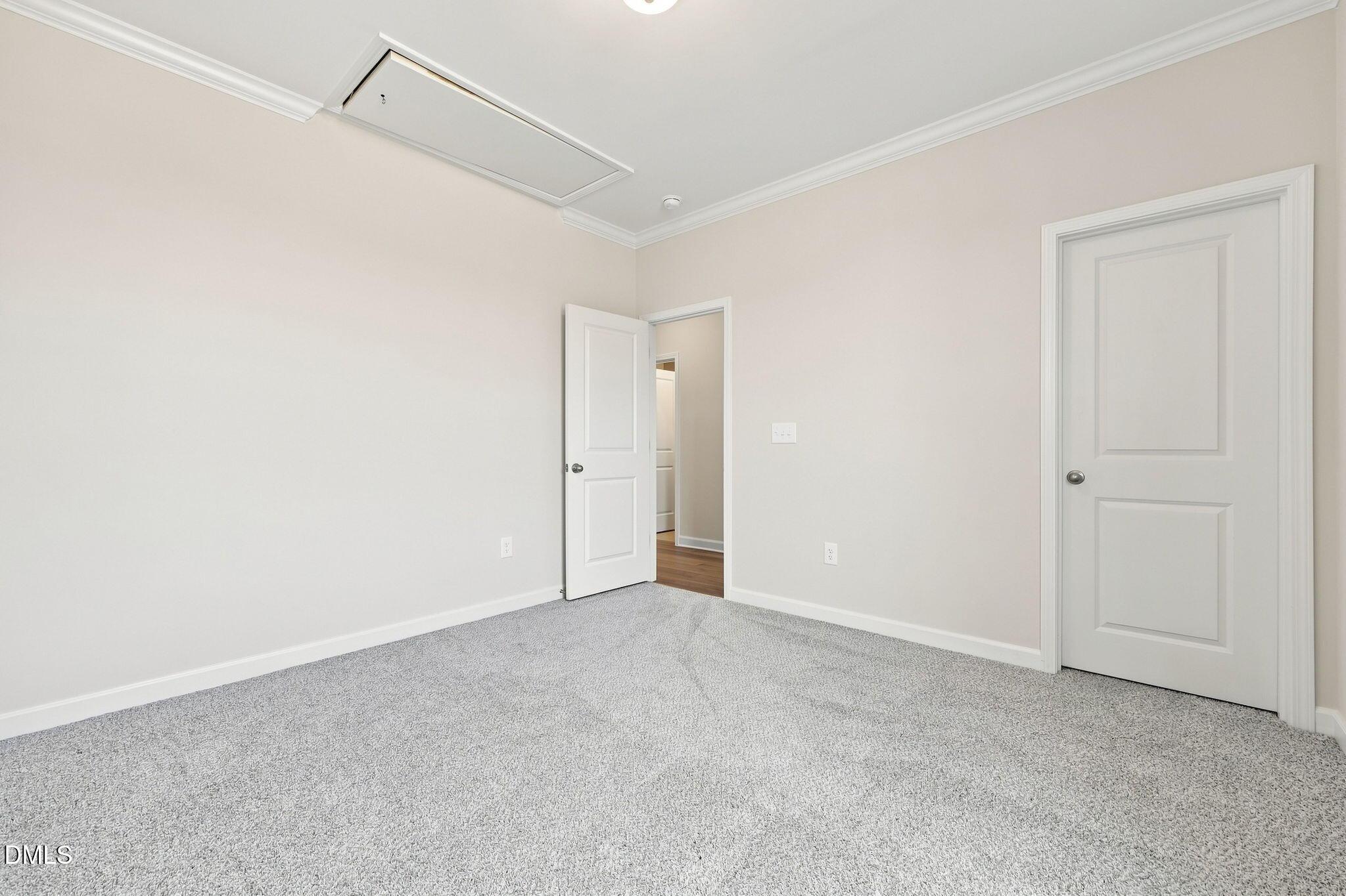 Spacious bedroom with neutral carpet in The Magnolia B floor plan at Retreat at North Main, Lillington, North Carolina.