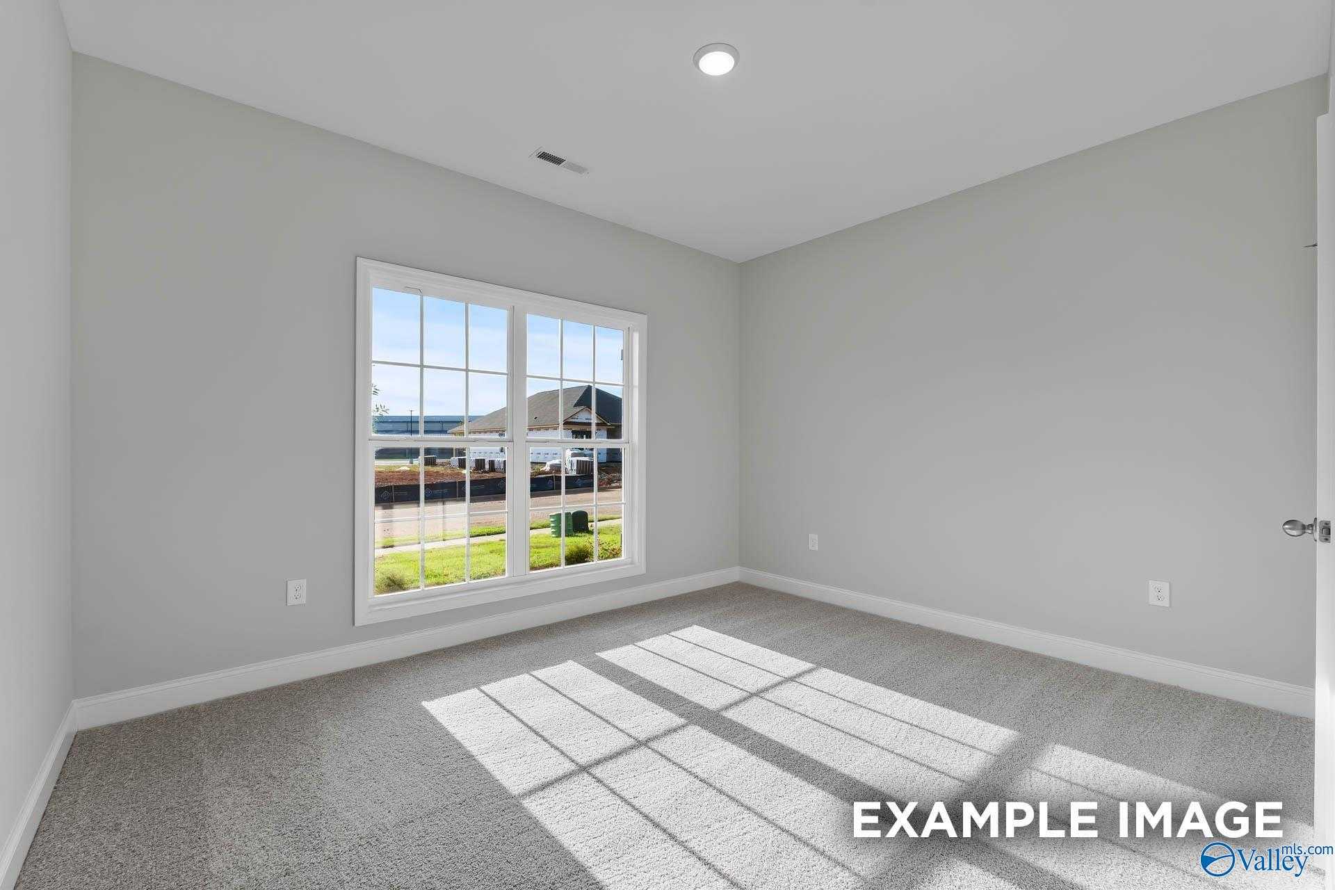 Bright bedroom with large window and natural light in The Daphne C 4-bedroom home by Davidson Homes, New Market, Alabama