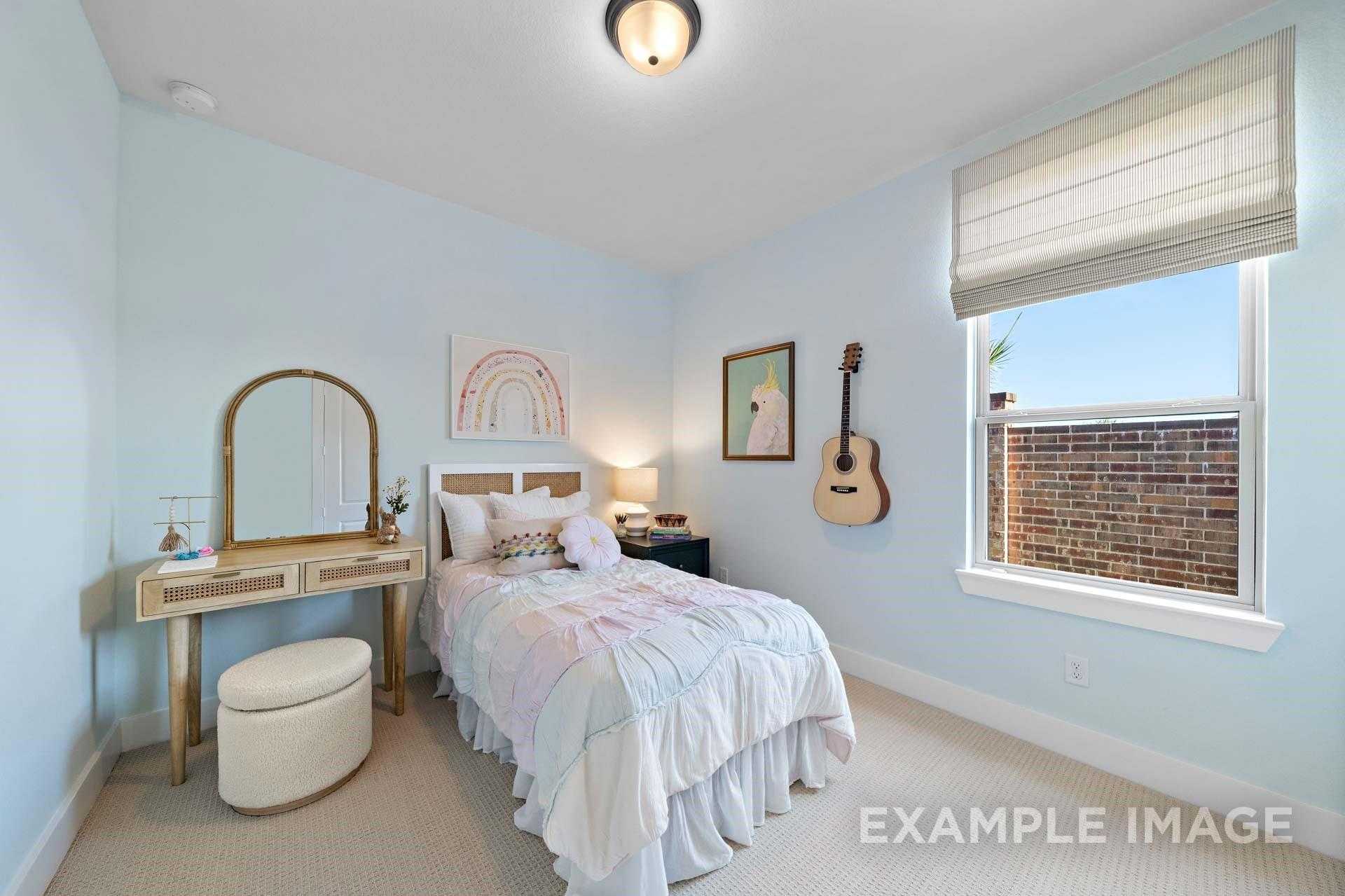 Charming light blue secondary bedroom with twin bed, ruffled bedding, vanity mirror, and wall guitar in Davidson Homes The Edward A, Lago Mar, Texas City