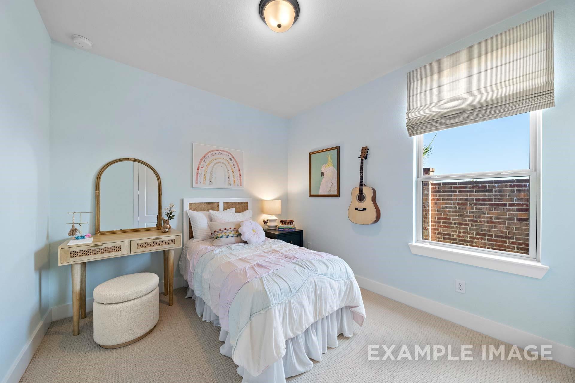 Charming light blue secondary bedroom with twin bed, ruffled bedding, vanity mirror, and wall guitar in Davidson Homes The Edward A, Lago Mar, Texas City