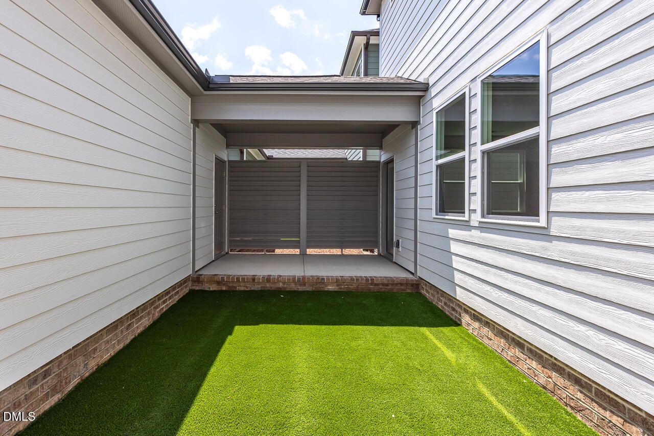 Private courtyard with synthetic turf and covered walkway at The Alexander C floor plan in Forestville Yard, Knightdale, NC.
