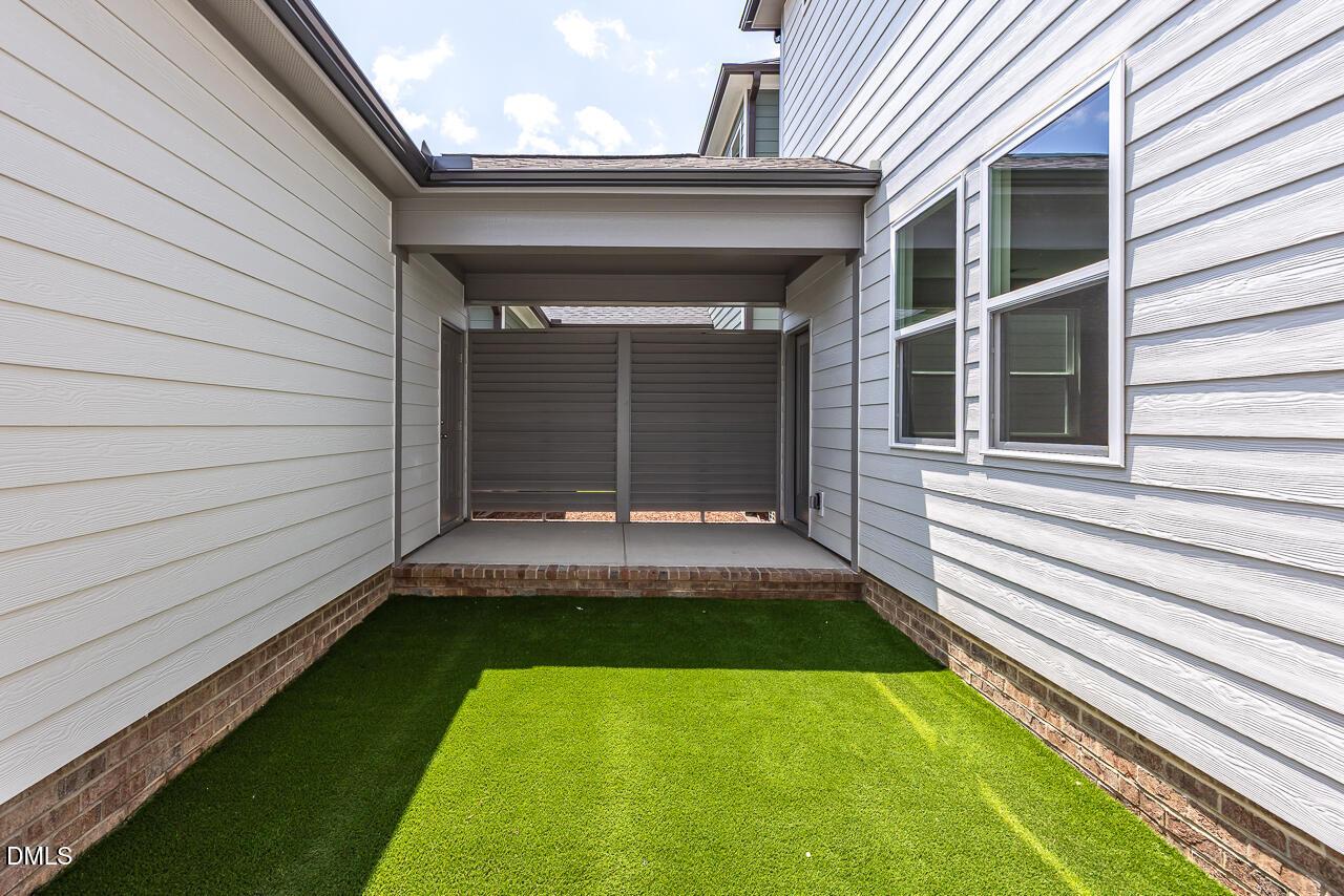 Private courtyard with synthetic turf and covered walkway at The Alexander C floor plan in Forestville Yard, Knightdale, NC.