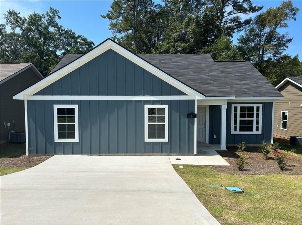 Navy blue sided 1-story 3-bedroom home with front porch, driveway, and landscaping in Summer Vineyard, Phenix City, Alabama
