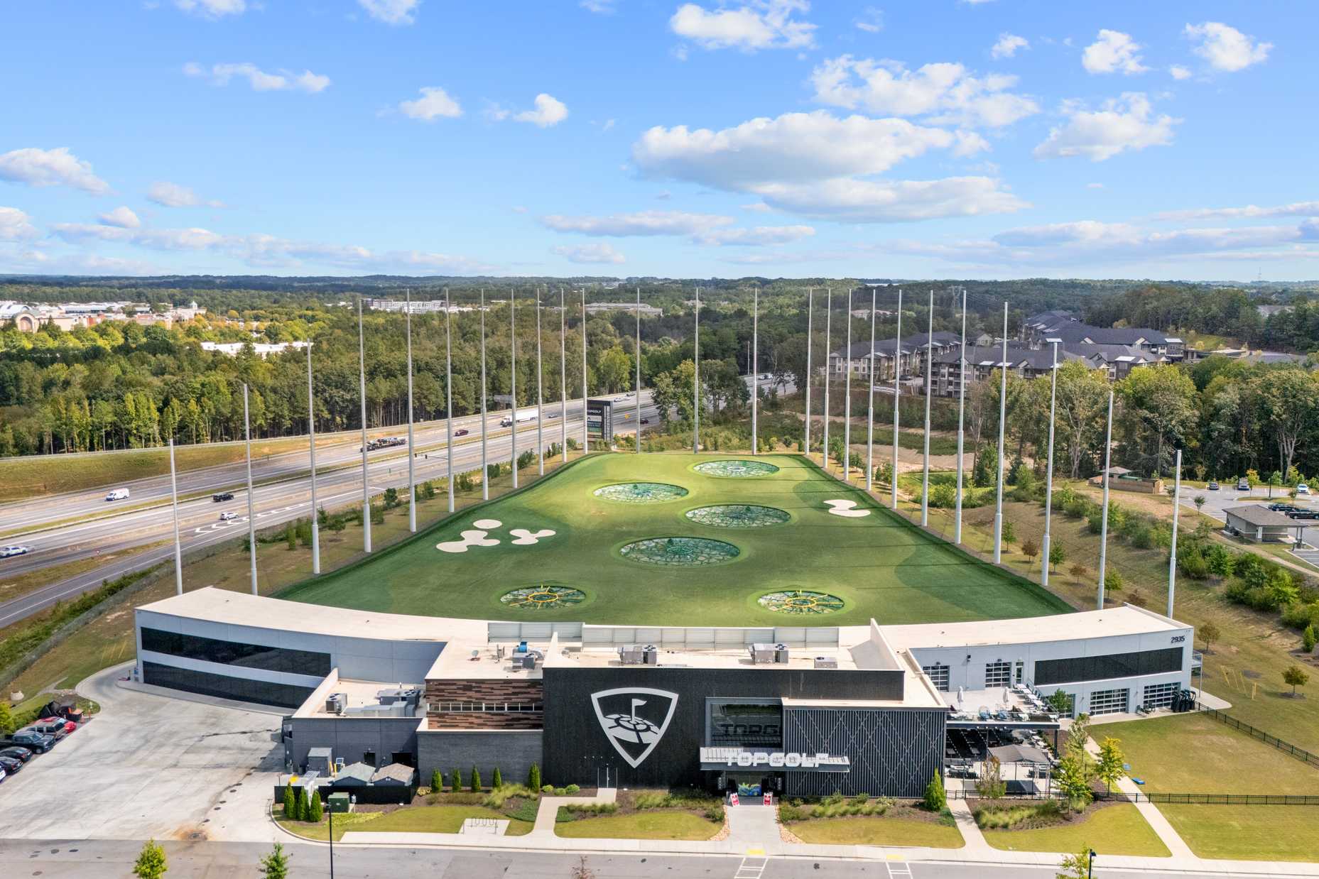 Aerial view of Topgolf facility near Melody Lakeside Estates in Buford, Georgia with multi-bay driving ranges, target greens, and modern clubhouse
