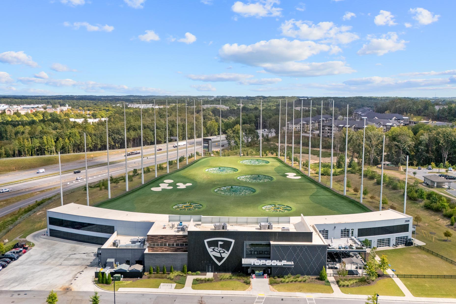 Aerial view of Topgolf facility near Melody Lakeside Estates in Buford, Georgia with multi-bay driving ranges, target greens, and modern clubhouse
