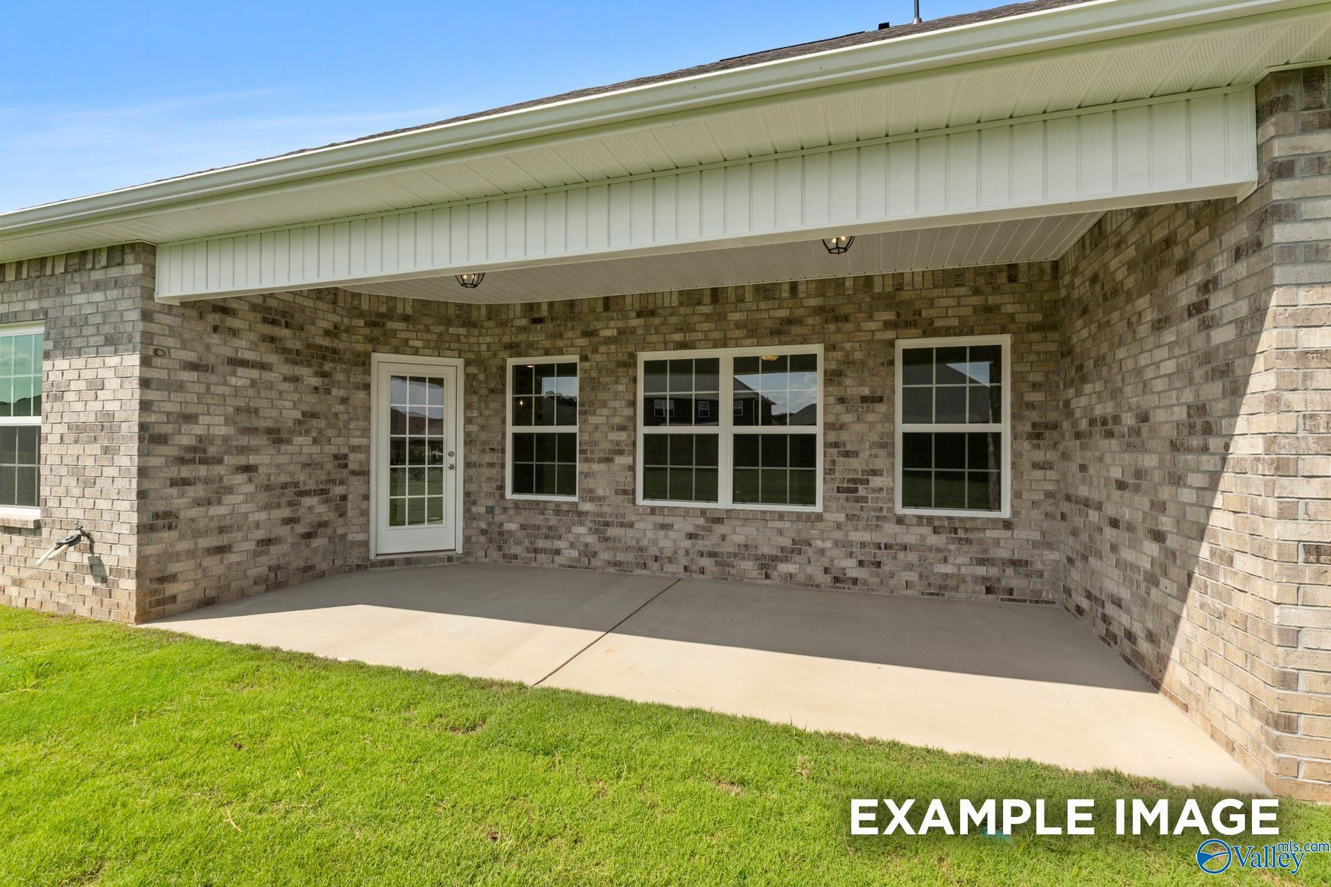 Covered brick patio with exterior door and windows at The Rockford B floor plan in Kendall Downs, Toney, Alabama.