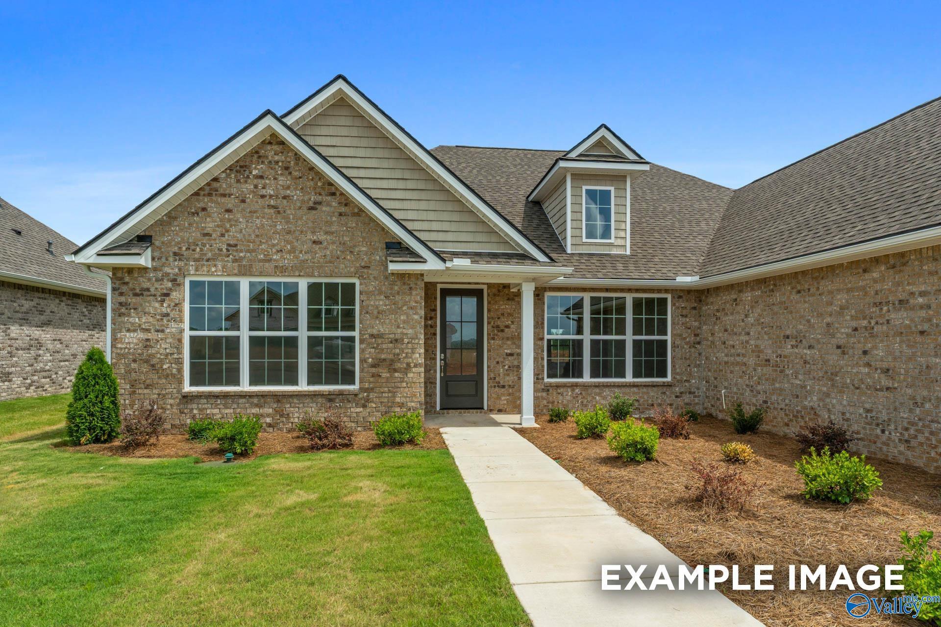 Modern brick single-story home with gabled roof, large windows, covered entry, and landscaped yard in Riverton Preserve, Huntsville, AL