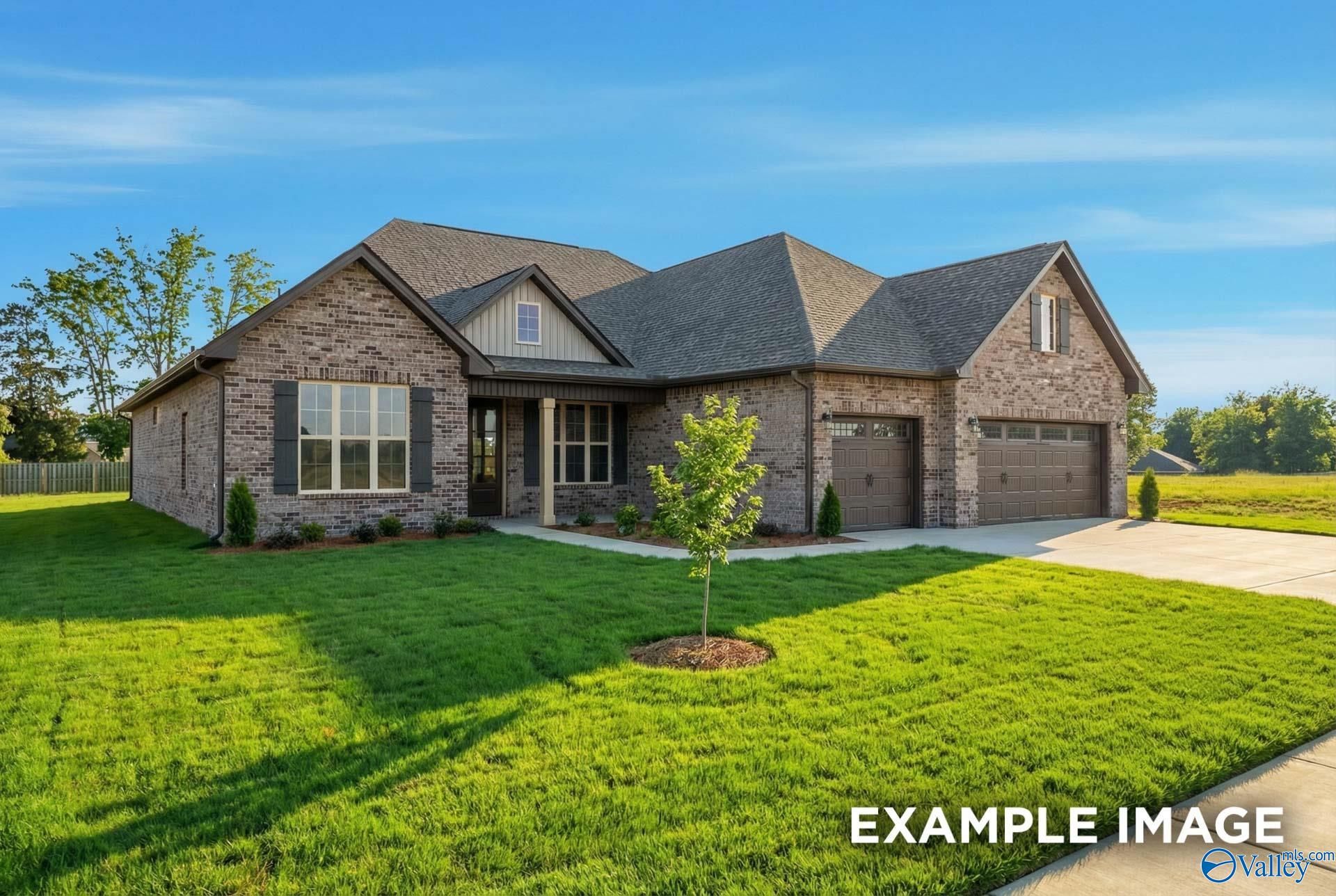 Modern brick 1.5-story Finleigh home with shingled roof, 3-car garage, large windows, and lush lawn in Hollon Meadow, Decatur, Alabama
