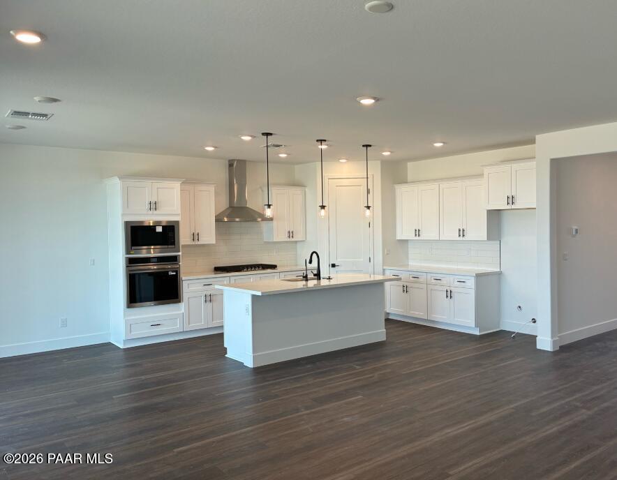 Modern white kitchen with center island and stainless steel appliances in The Durango II G at South Ranch, Prescott, AZ.