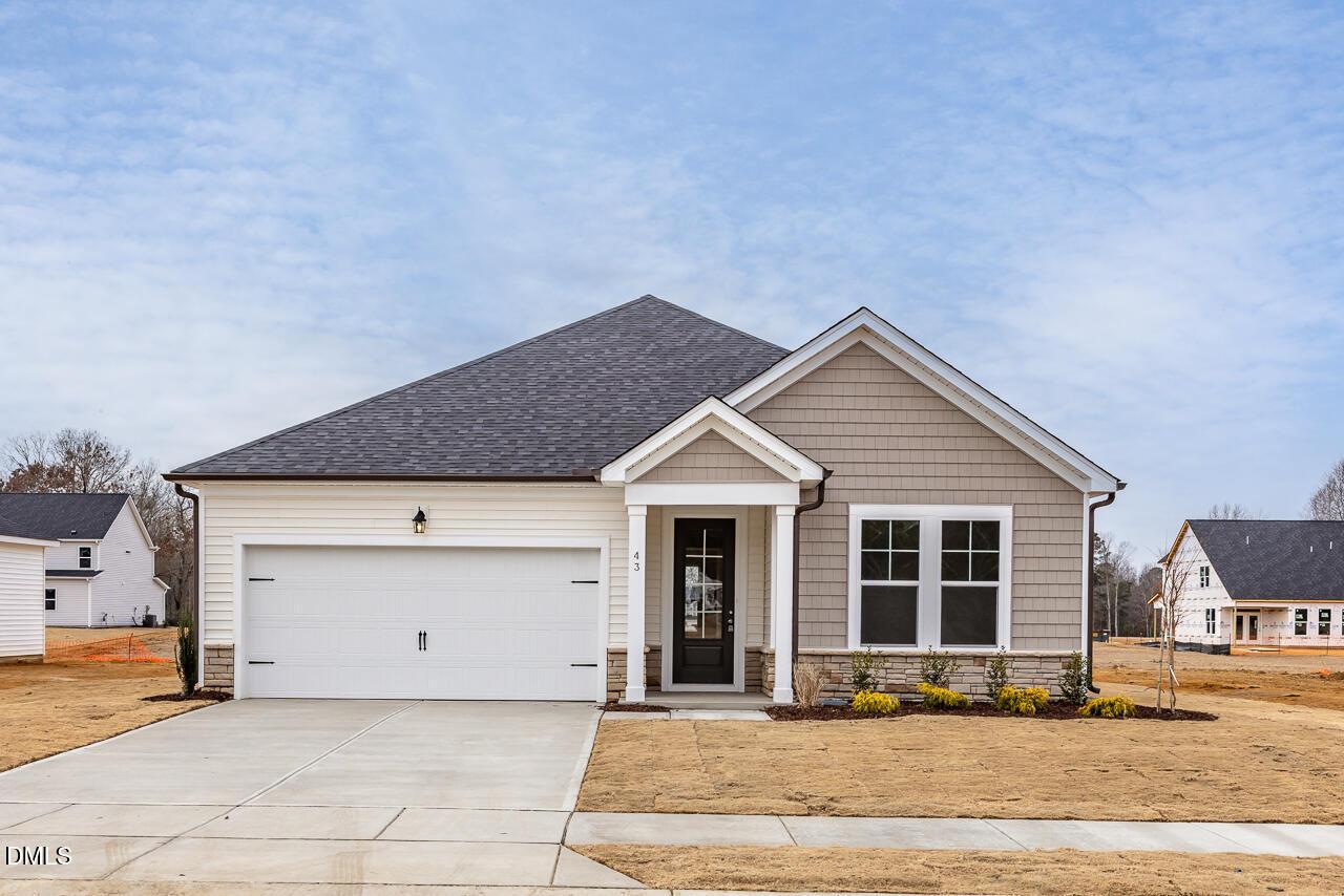 Modern 1-story 3-bedroom home with 2-car garage, front porch, and shake siding in Retreat at North Main, Lillington, North Carolina by Davidson Homes The Daphne C