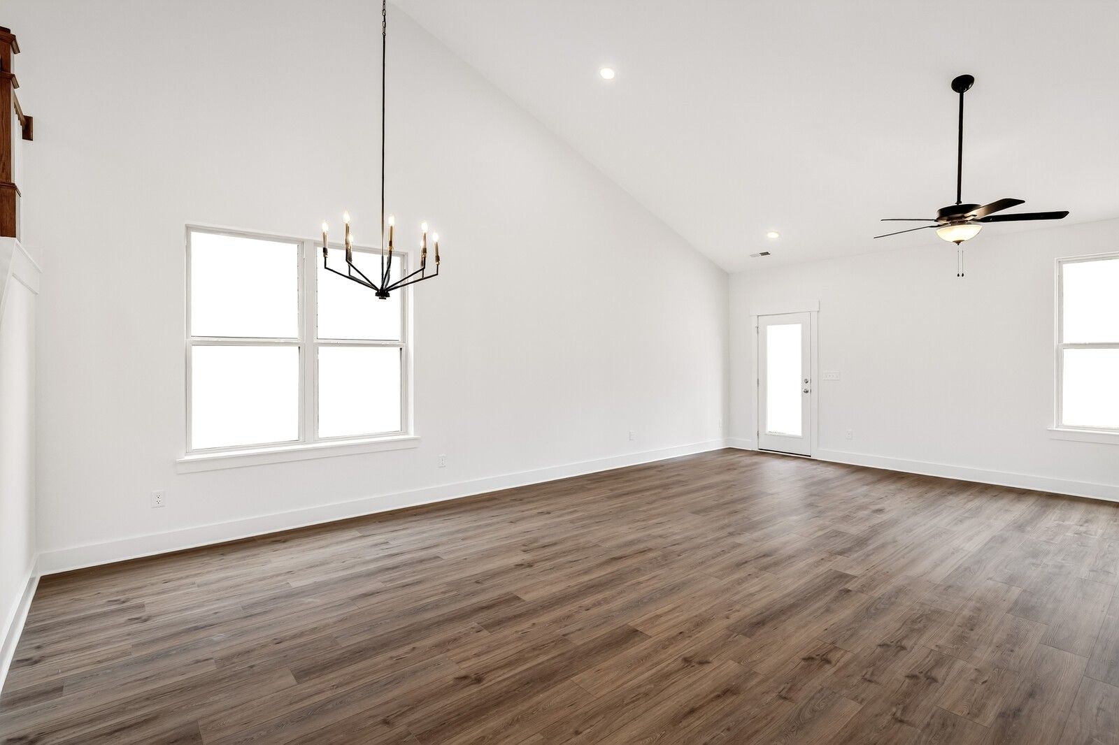 Spacious living room with vaulted ceilings, ceiling fans, chandelier, large windows and hardwood floors in 5-bedroom Ridgeport C home, Gallatin, TN