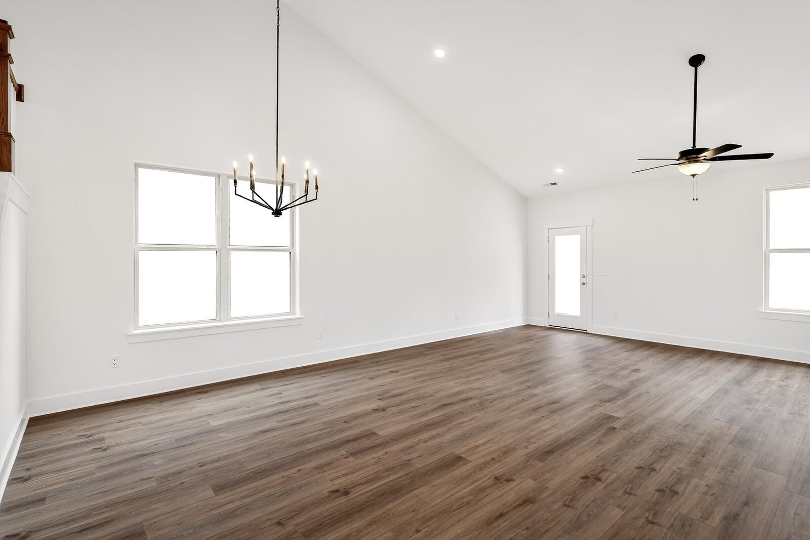 Spacious living room with vaulted ceilings, ceiling fans, chandelier, large windows and hardwood floors in 5-bedroom Ridgeport C home, Gallatin, TN