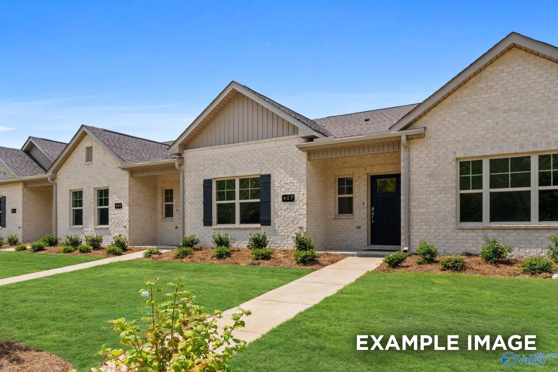 Row of modern single-story beige brick homes with gabled roofs, shutters, and landscaped lawns in The Retreat at Cain Park, Hartselle, Alabama