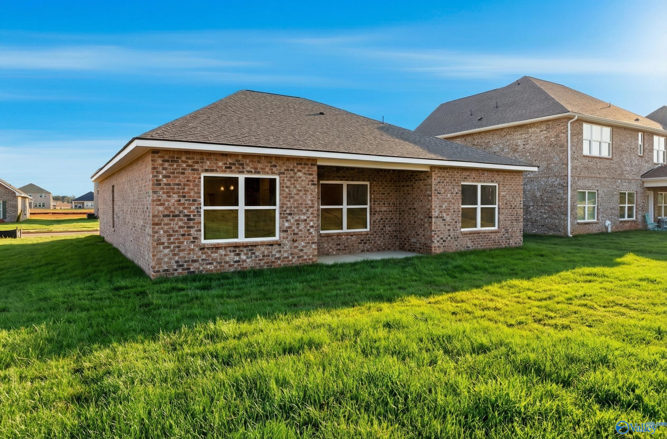 Single-story brick home with covered patio, large windows, and lush green yard in Walker's Hill, Meridianville, Alabama - Davidson Homes Asheville C