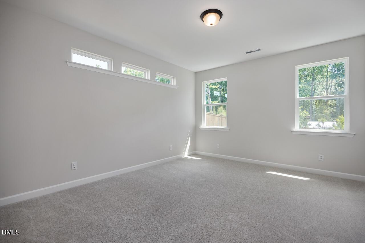 Bright, carpeted bedroom with natural light in The Ashport L floor plan at Sage on North Main, Wake Forest, NC.
