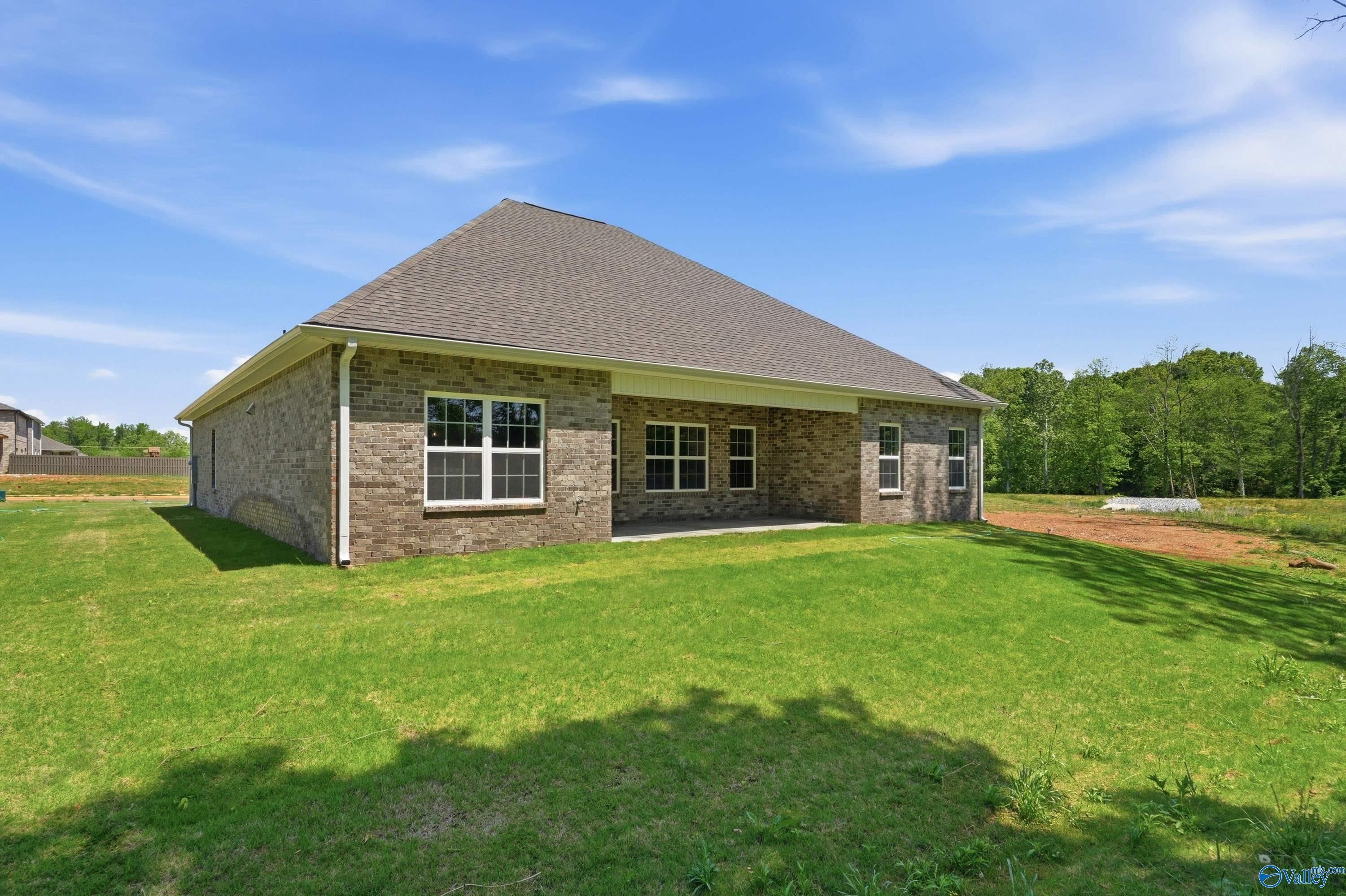 Single-story brick home with covered porch, gabled roof, and lush green lawn in The Meadows, Athens, Alabama – Davidson Homes Rockford B