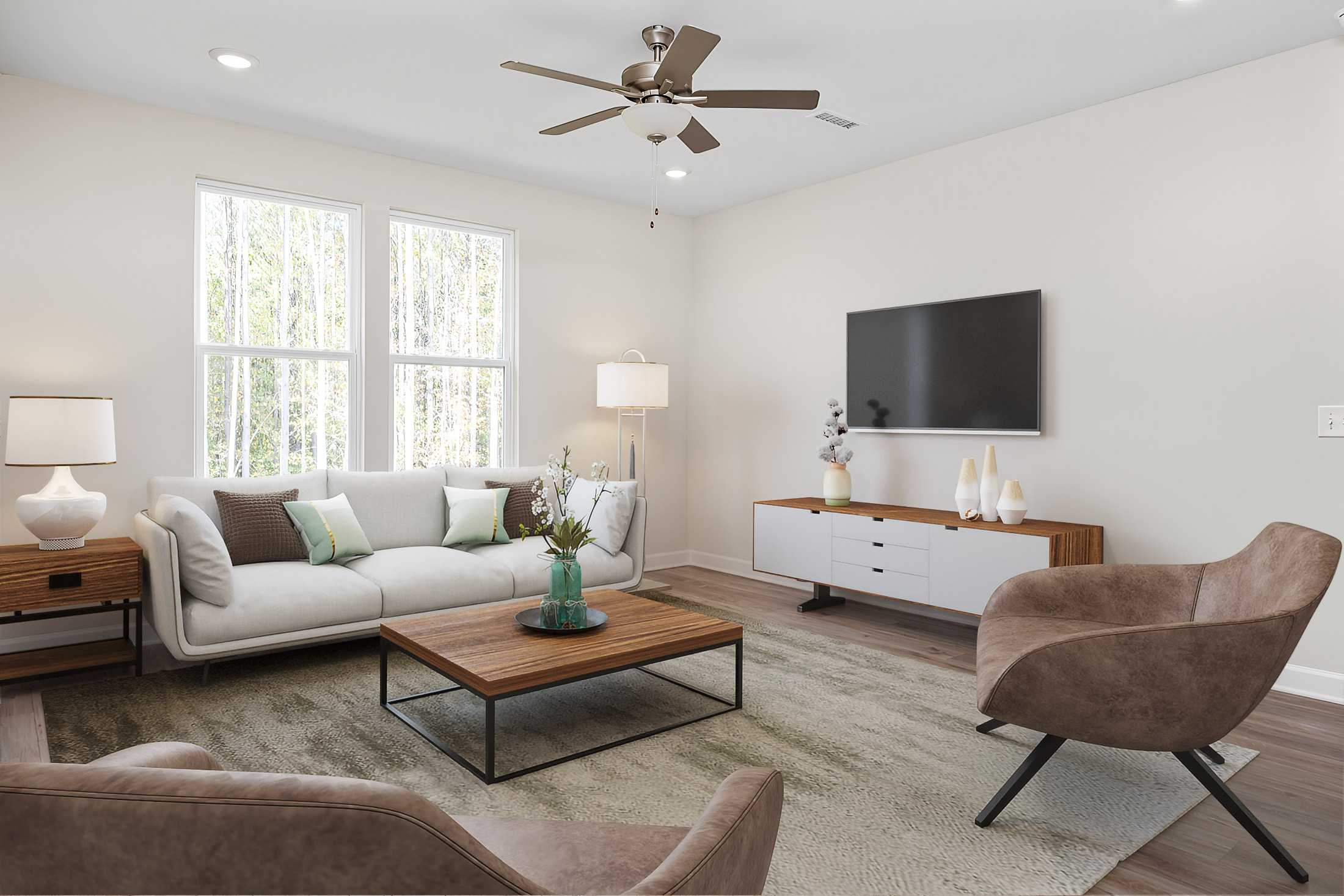 Cozy living room in Stagecoach Corner by Davidson Homes in Mebane NC with gray sofa, leather armchair, wooden coffee table, and large windows