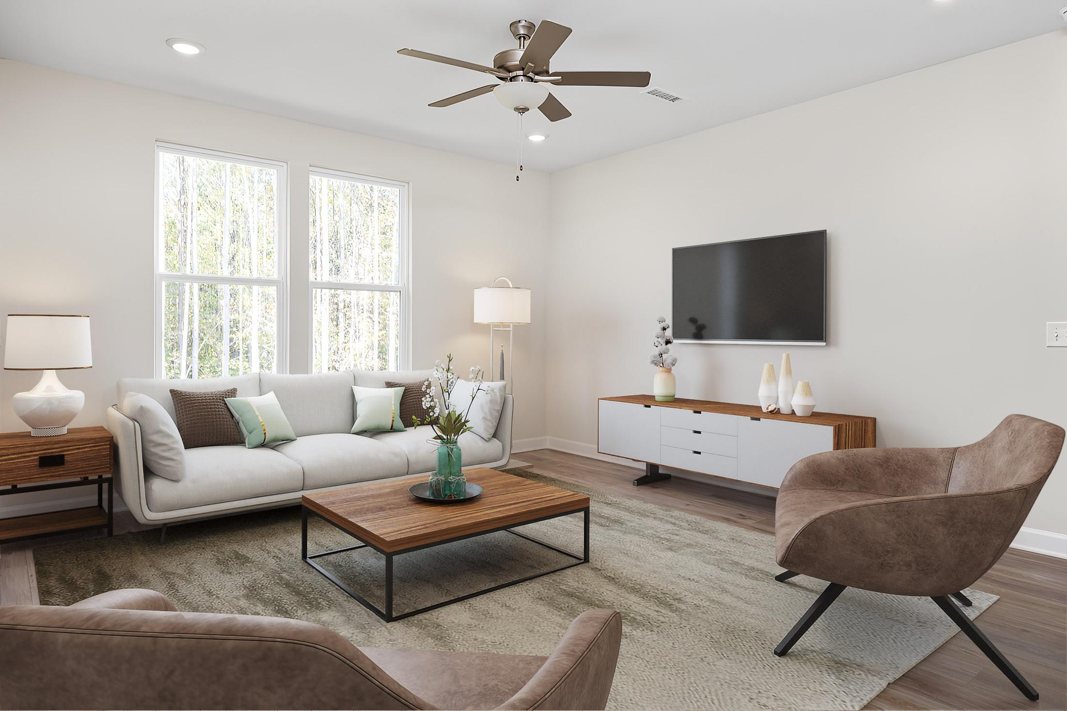 Cozy living room in Stagecoach Corner by Davidson Homes in Mebane NC with gray sofa, leather armchair, wooden coffee table, and large windows