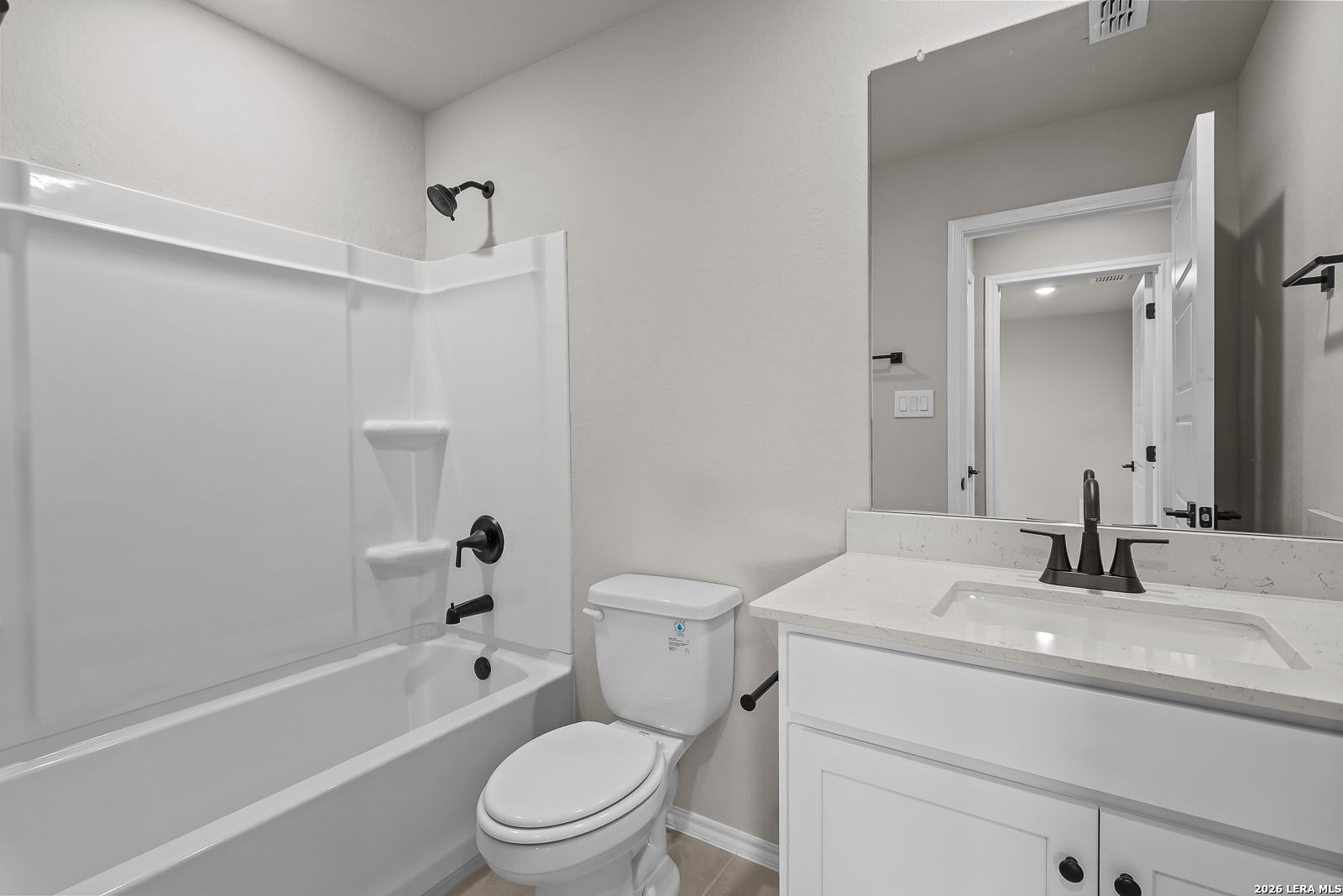 Modern bathroom with tub-shower combo, white vanity and quartz countertop in Davidson Homes Sequoia C plan, Royal Crest, San Antonio