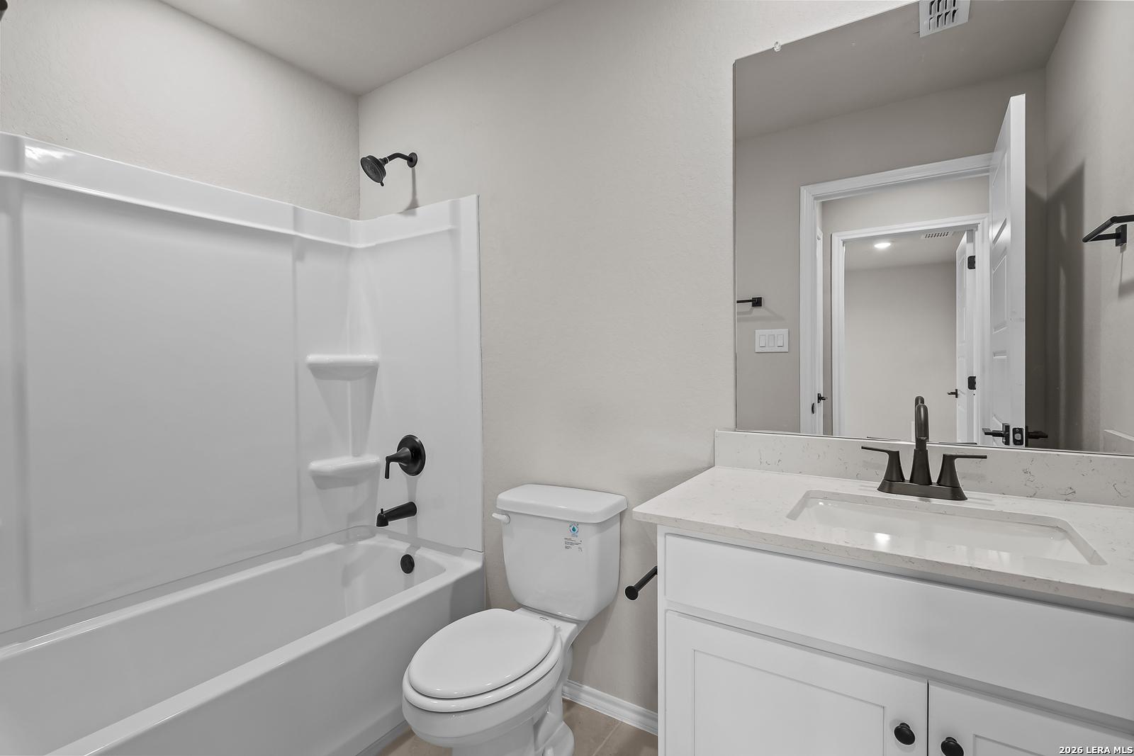Modern bathroom with tub-shower combo, white vanity and quartz countertop in Davidson Homes Sequoia C plan, Royal Crest, San Antonio