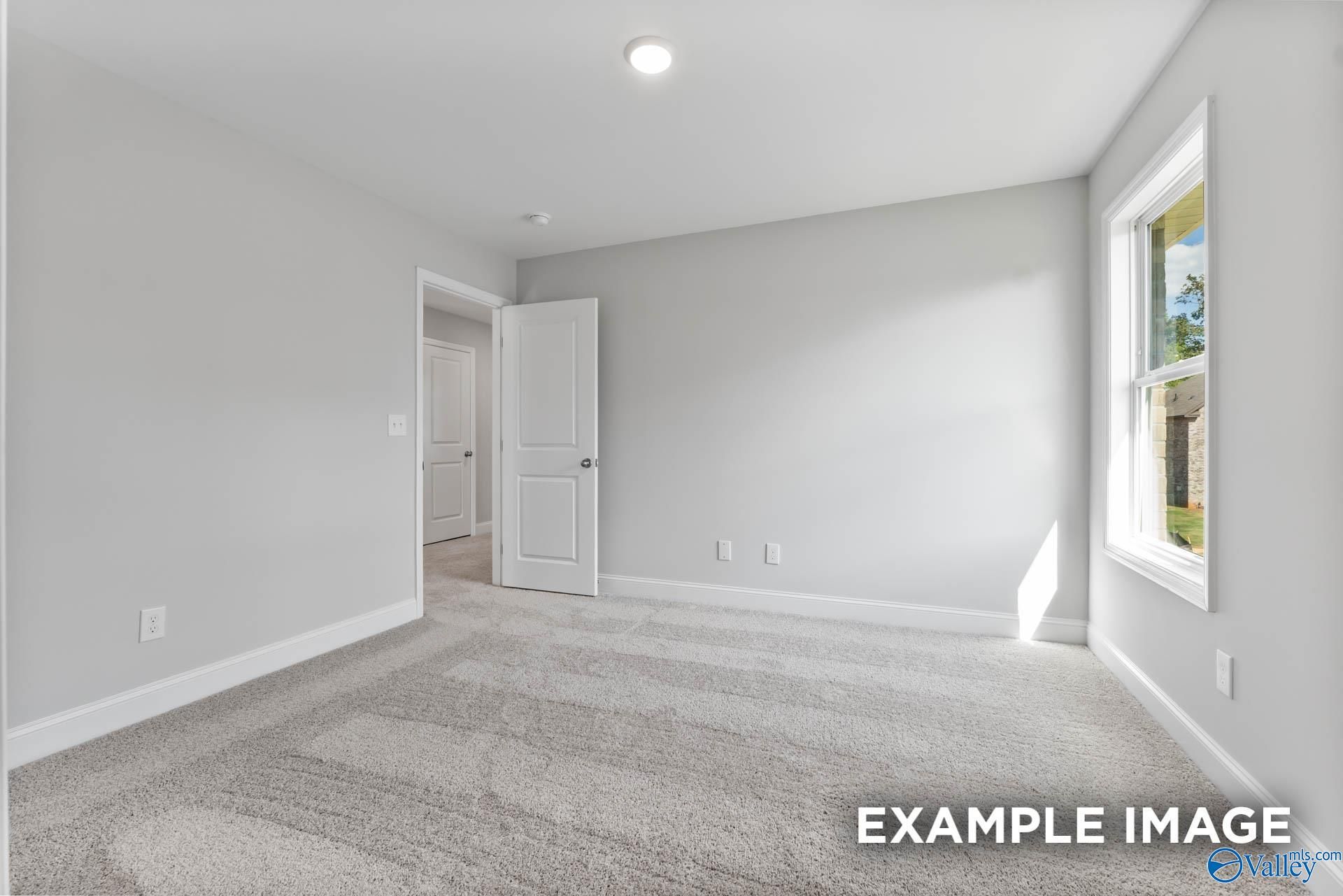 Bright secondary bedroom with gray walls, large window, and striped carpet in Davidson Homes The Chelsea D, New Market, Alabama