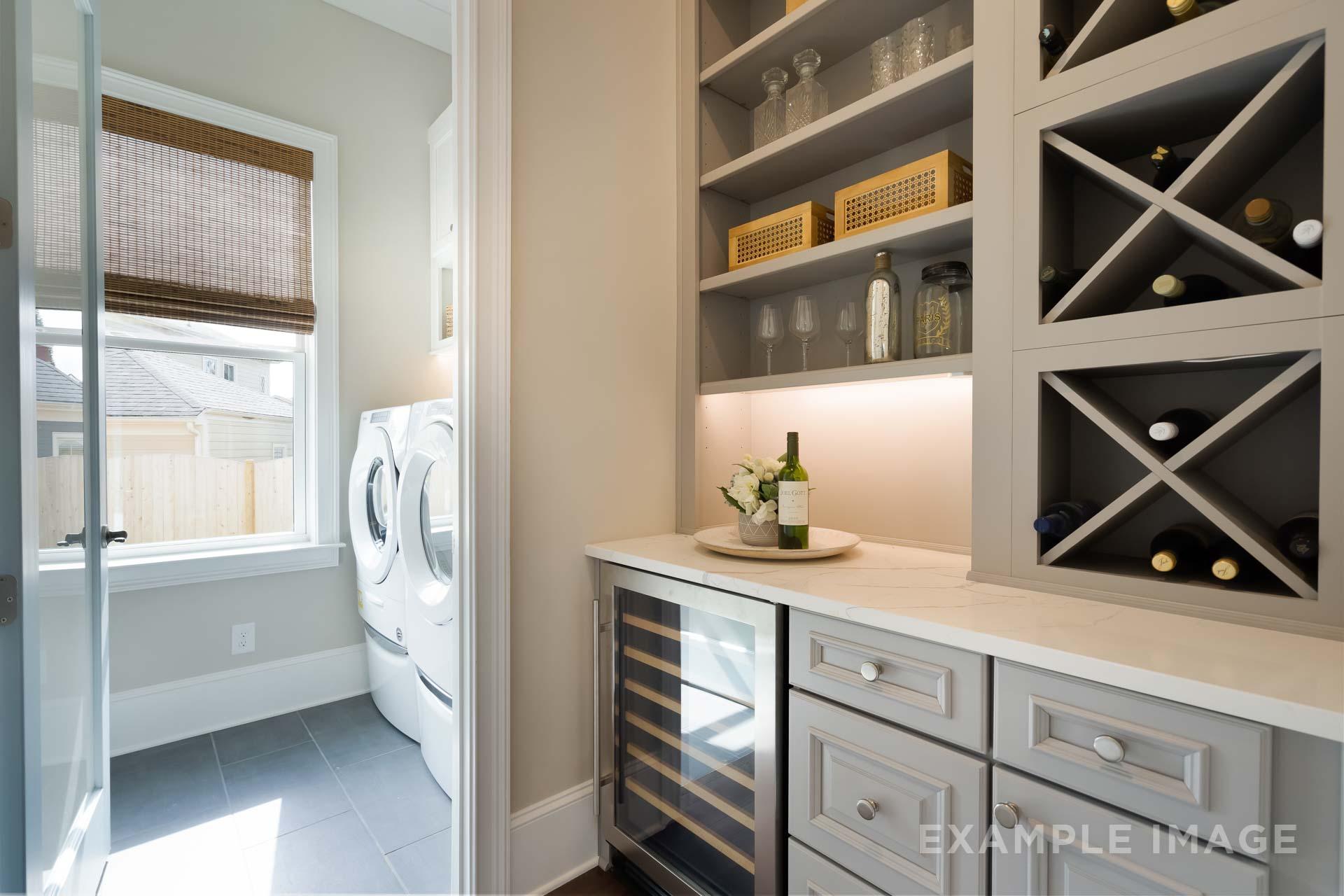 Modern laundry room and butler's pantry in The Seaside home design by Davidson Homes featuring wine rack, cooler, and washer-dryer