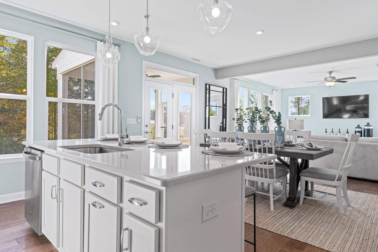Open-concept kitchen and dining area in The Hemlock featuring a large island, pendant lighting, and modern finishes.