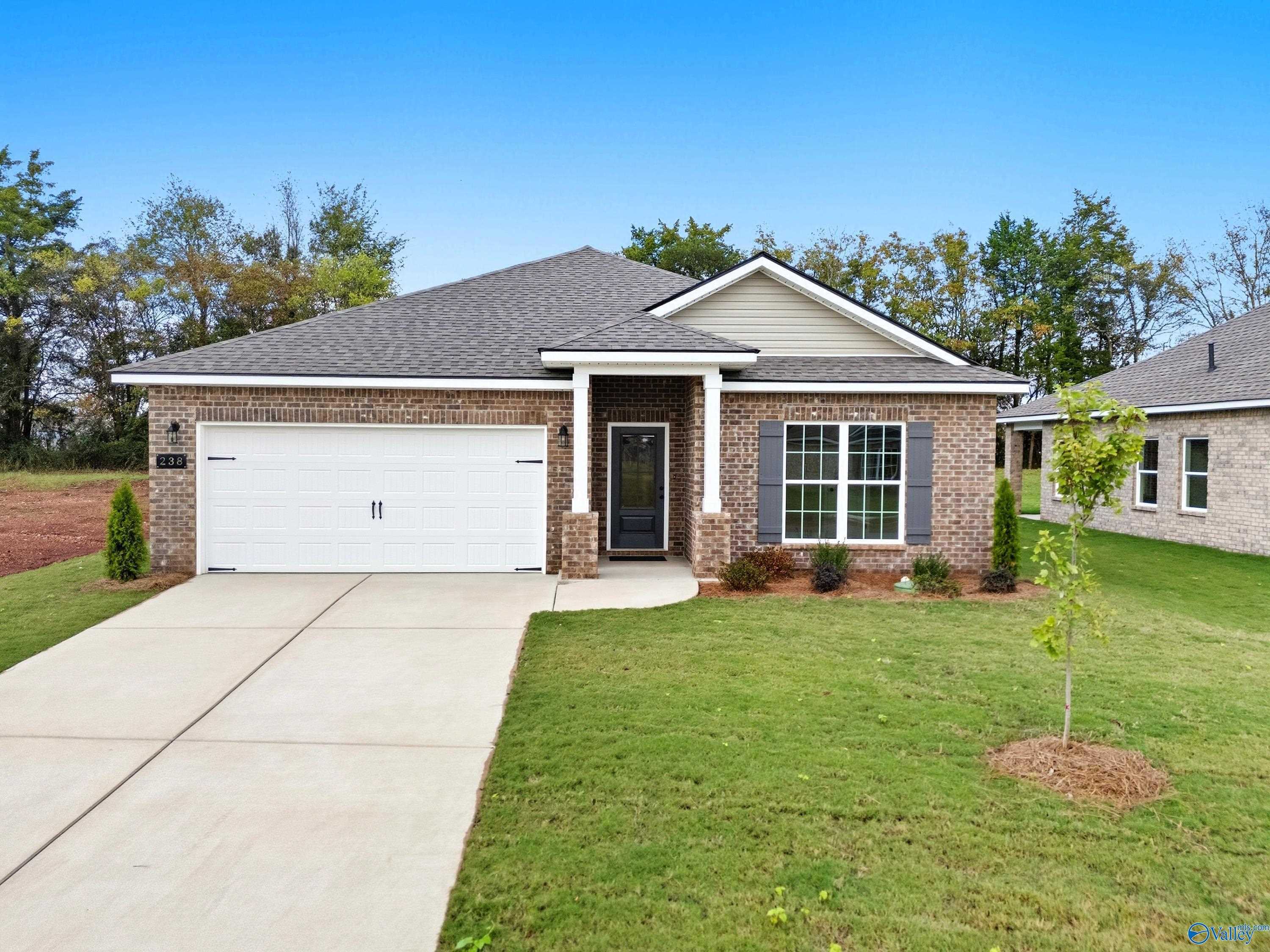 Modern single-story brick home with 2-car garage, covered entry, and landscaped yard in Lynn Meadows, Meridianville, Alabama