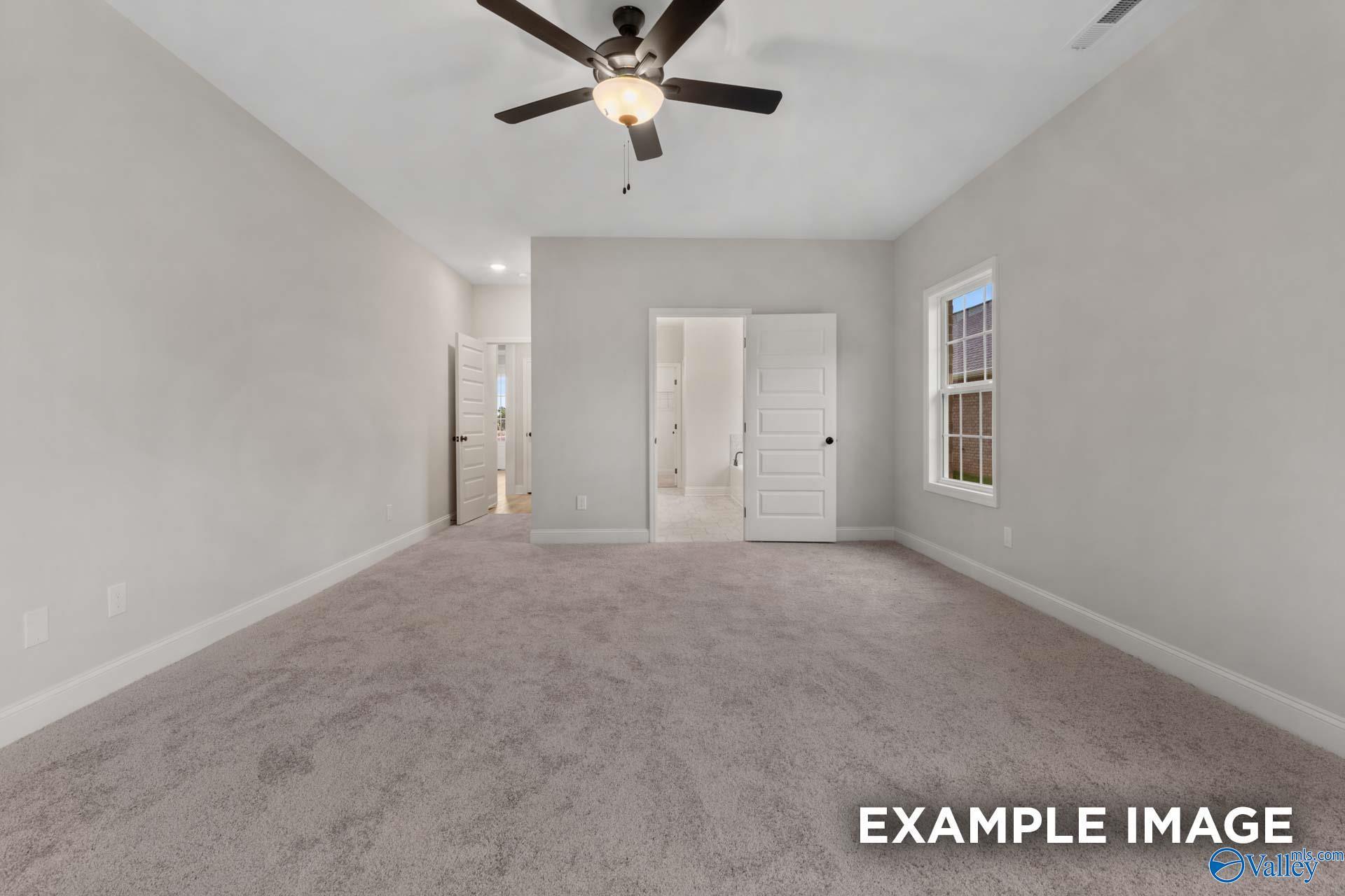Spacious master bedroom with ceiling fan, en-suite bathroom, and walk-in closet in Davidson Homes The Finleigh, Meridianville, Alabama