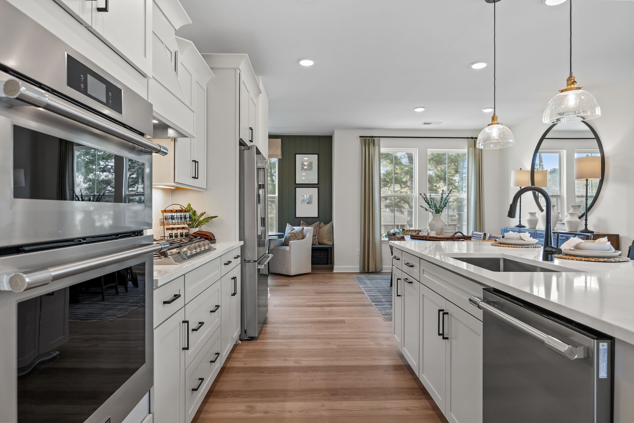Spacious white kitchen at Forestville Yard Townhomes in Knightdale NC with stainless appliances quartz island and hardwood floors