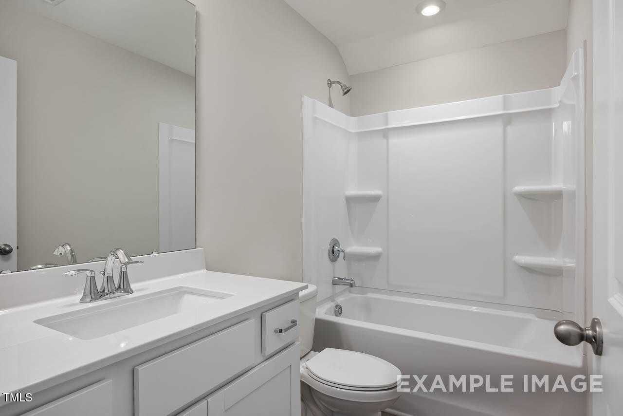 Modern bathroom with white vanity, soaking tub, glass shower enclosure in The Hickory II B by Davidson Homes, Lillington, NC
