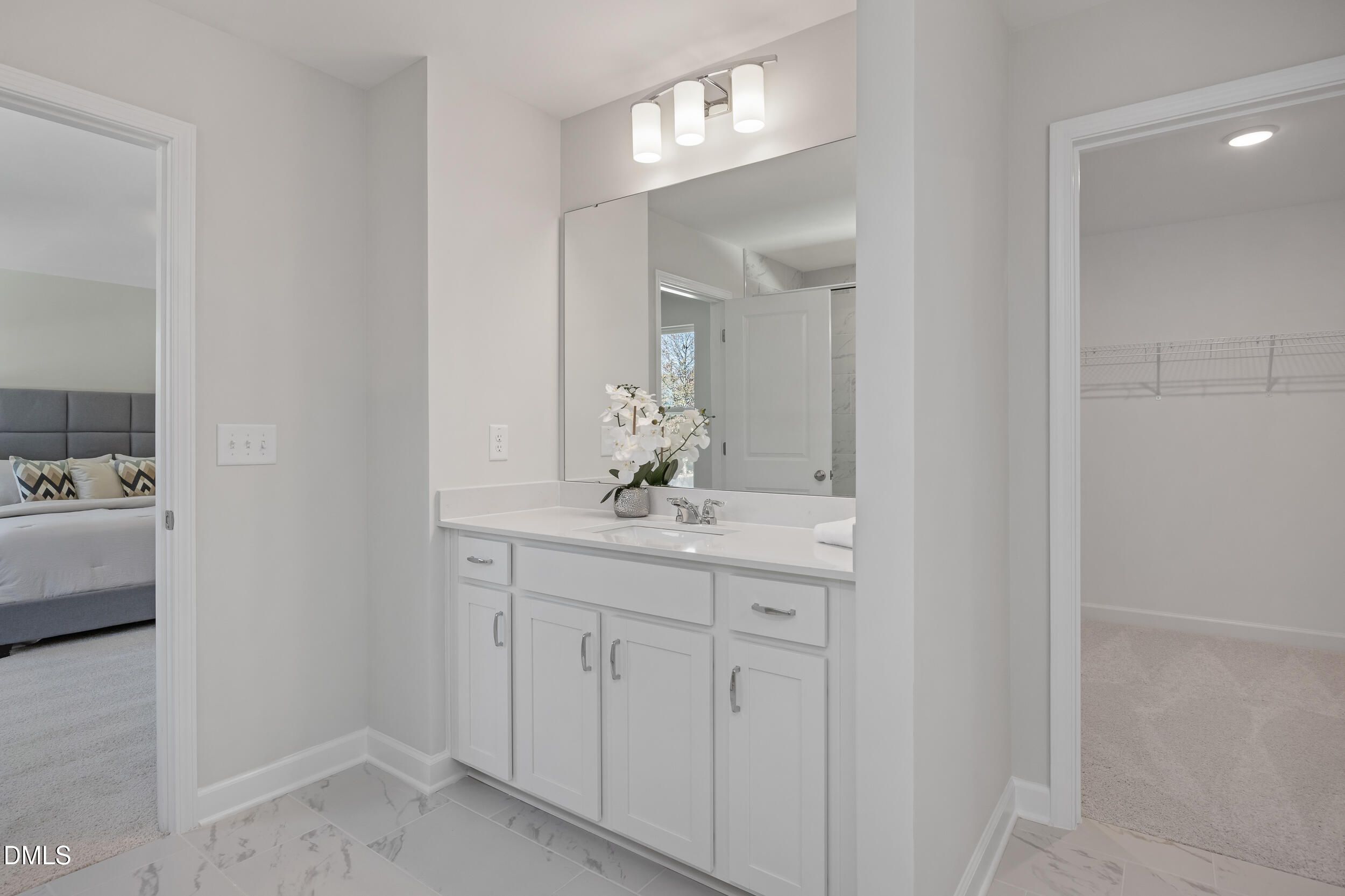 Elegant master bathroom featuring white double vanity, large mirror, and orchids in Davidson Homes The Preston C, Lillington, NC