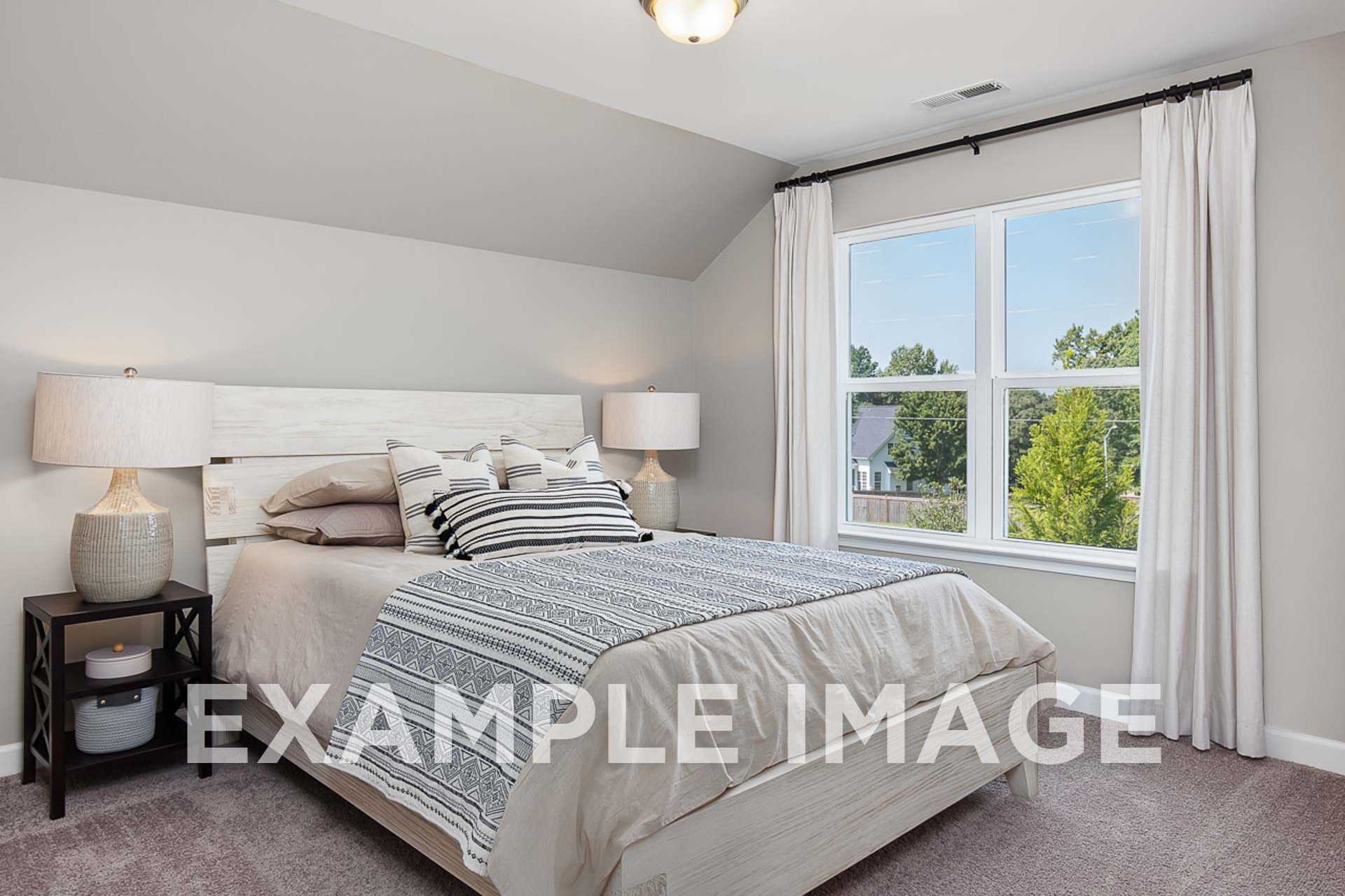 Spacious master bedroom in The Ash E with vaulted ceiling, queen bed, neutral bedding, and large window views