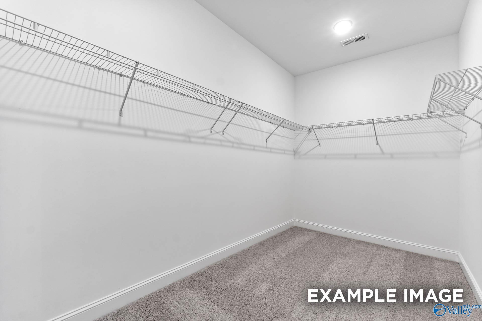 Spacious walk-in closet with wire shelving and hanging rods in Davidson Homes The Finleigh, Riverton Preserve, Huntsville, Alabama