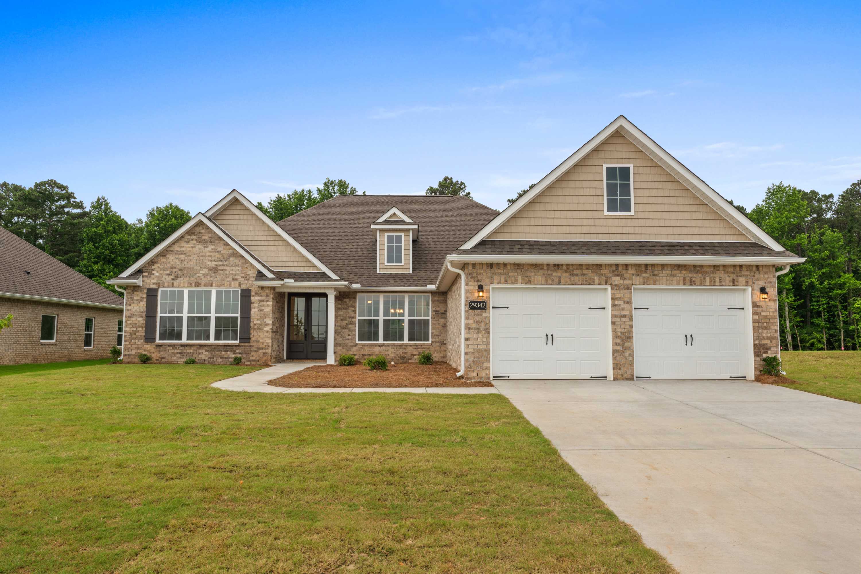 Front elevation of The Oxford 4-bedroom single-story home with brick accents, siding, 2-car garage, driveway, and green lawn in Meridianville AL