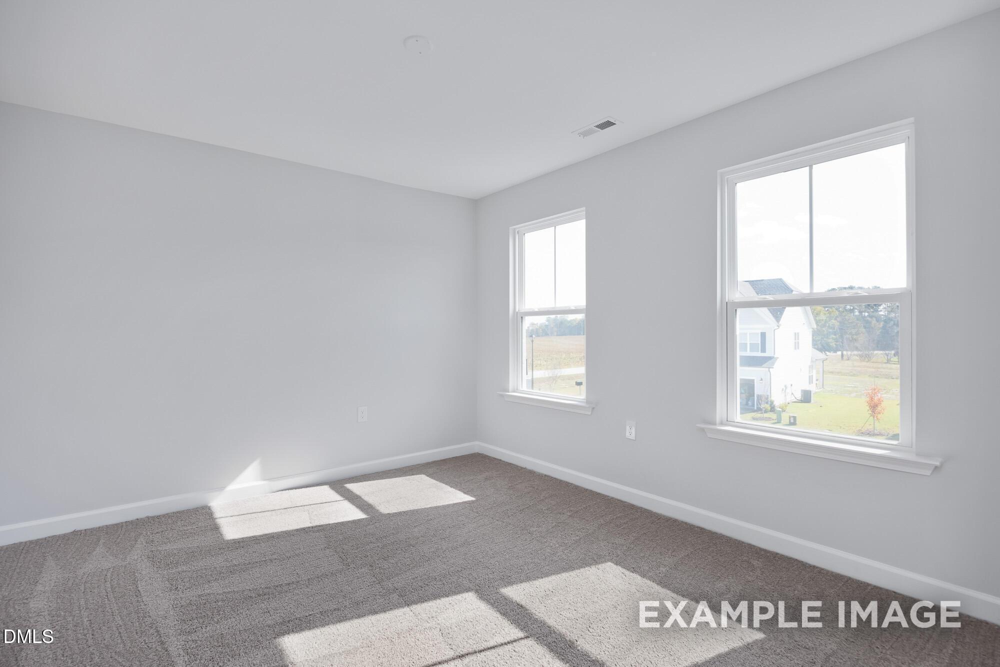 Bright empty bedroom with large windows and natural light in 5-bedroom The Hickory II B home, Lillington, NC