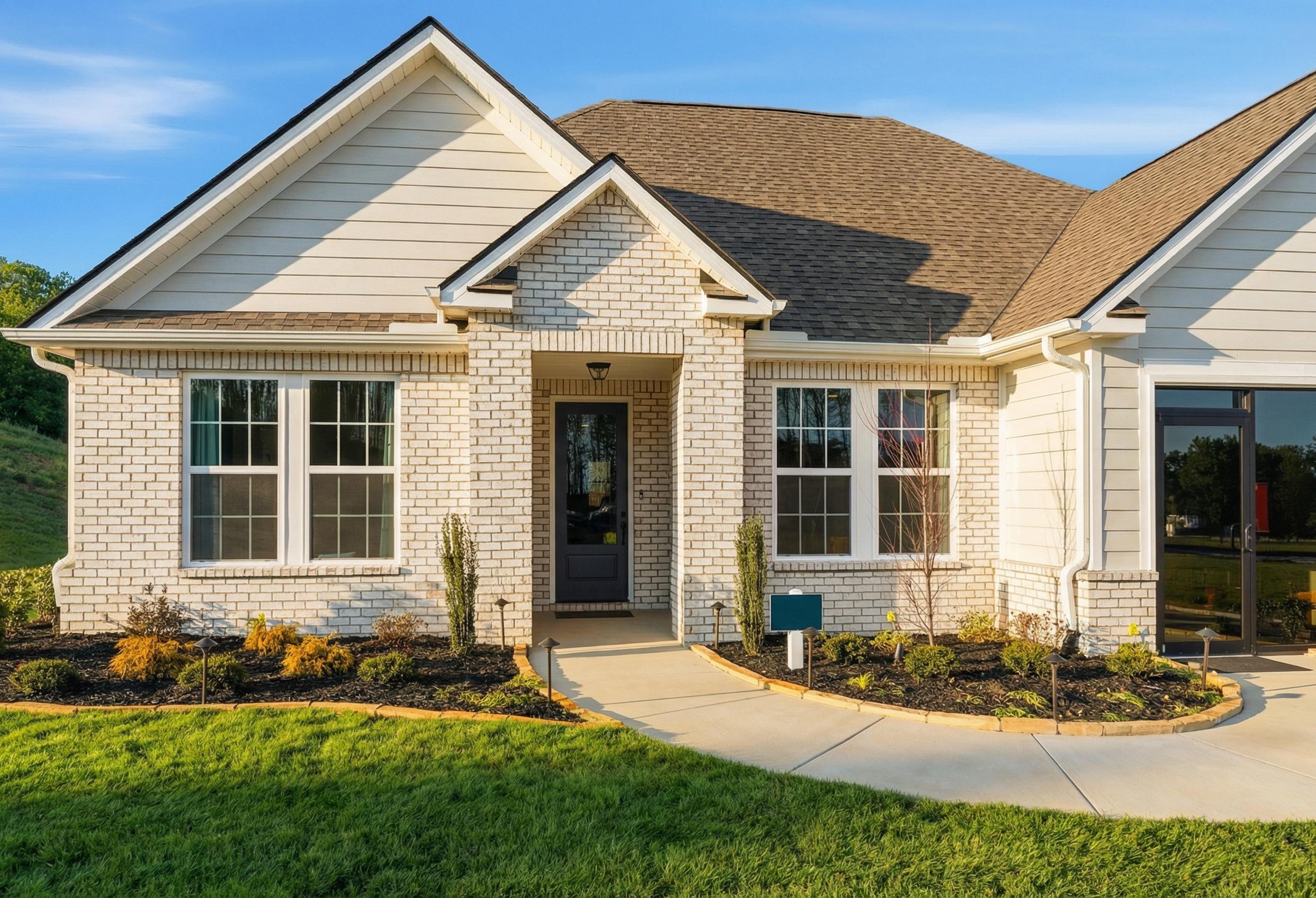 The Hibiscus E single-family home elevation featuring a cement and brick exterior with a welcoming front entryway.
