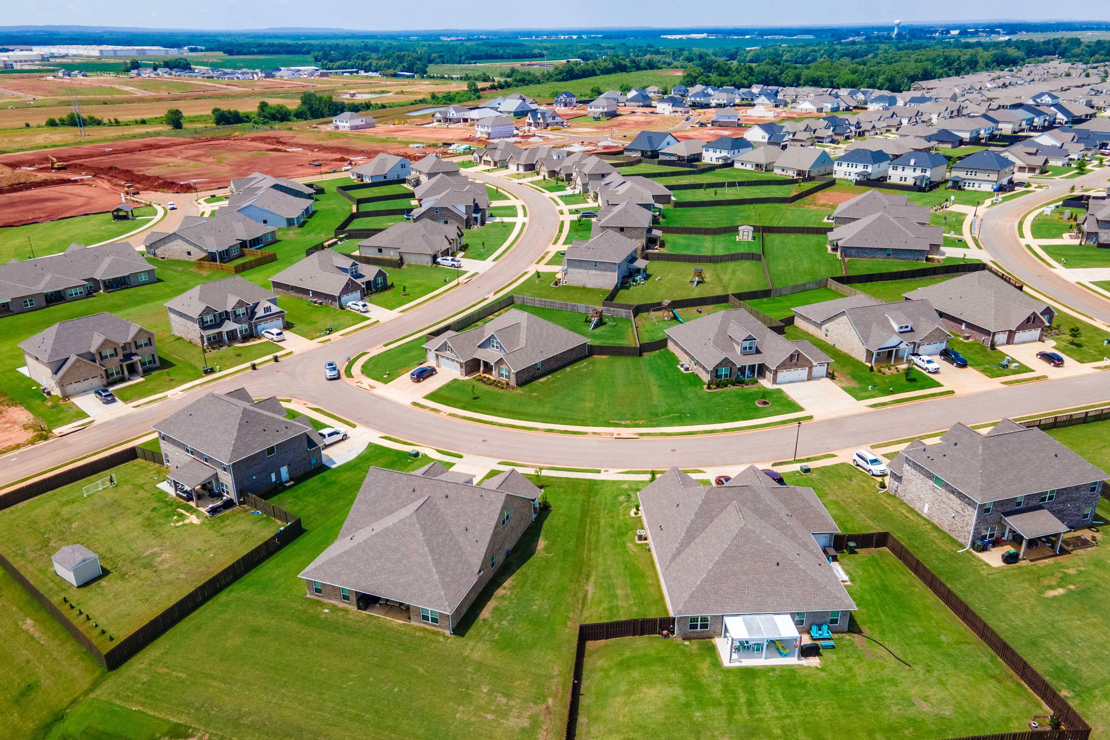 Aerial view of new single-family homes in Barnett's Crossing, Madison Alabama by Davidson Homes with curved streets and green lawns