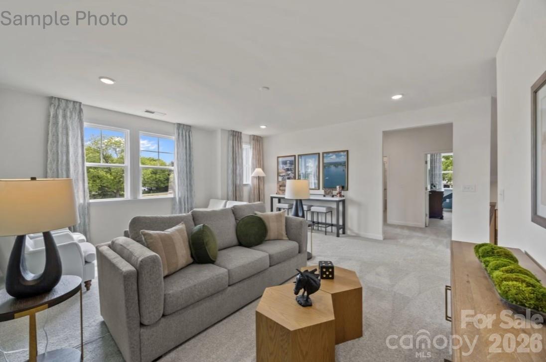 Bright, open-concept living area with plush gray sofa in The Beech B floor plan at Enclave at Belmont, North Carolina.