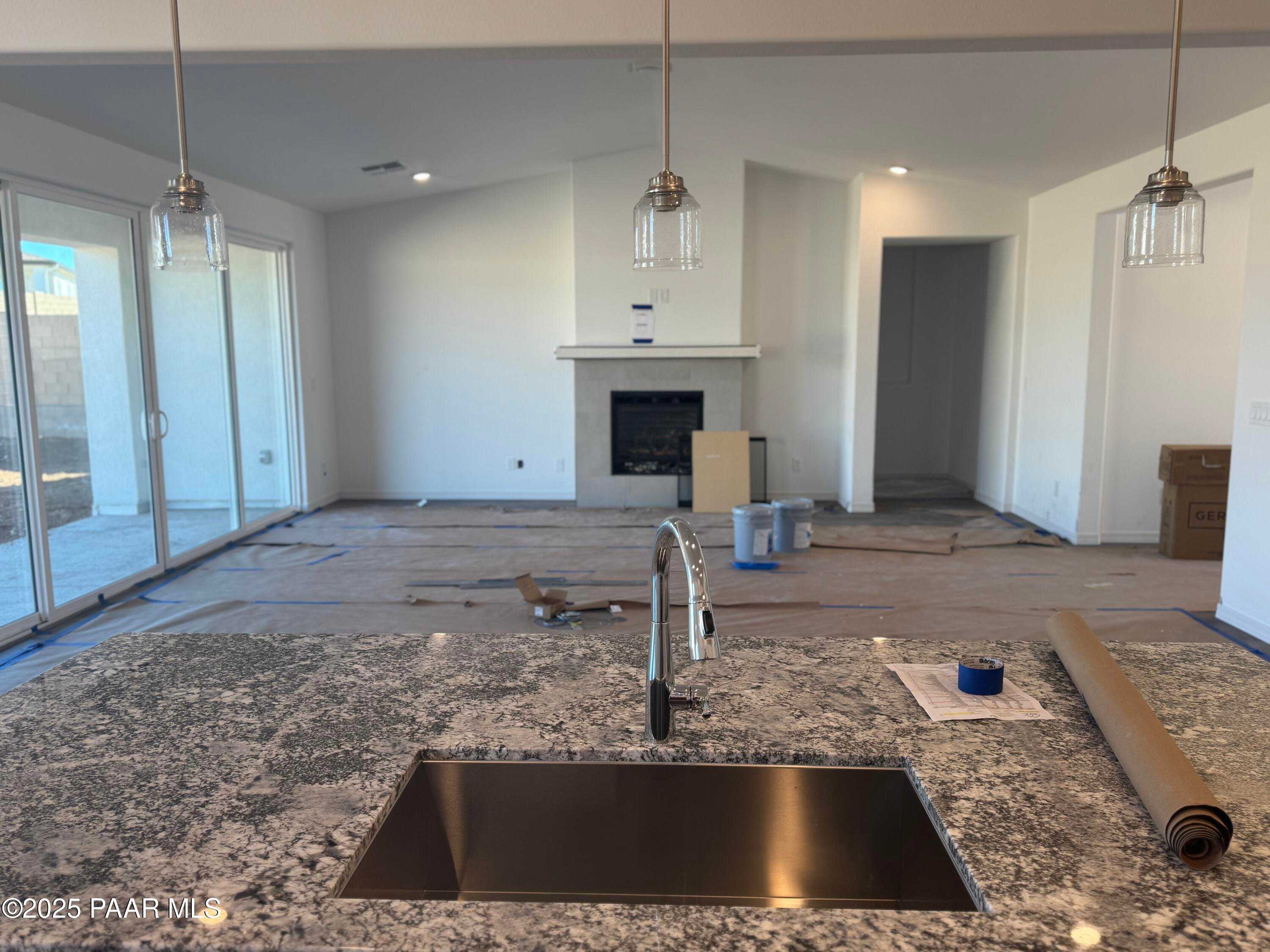 Modern open-concept kitchen with granite island, stainless sink, and pendant lights in Davidson Homes The Summit A, Prescott, Arizona